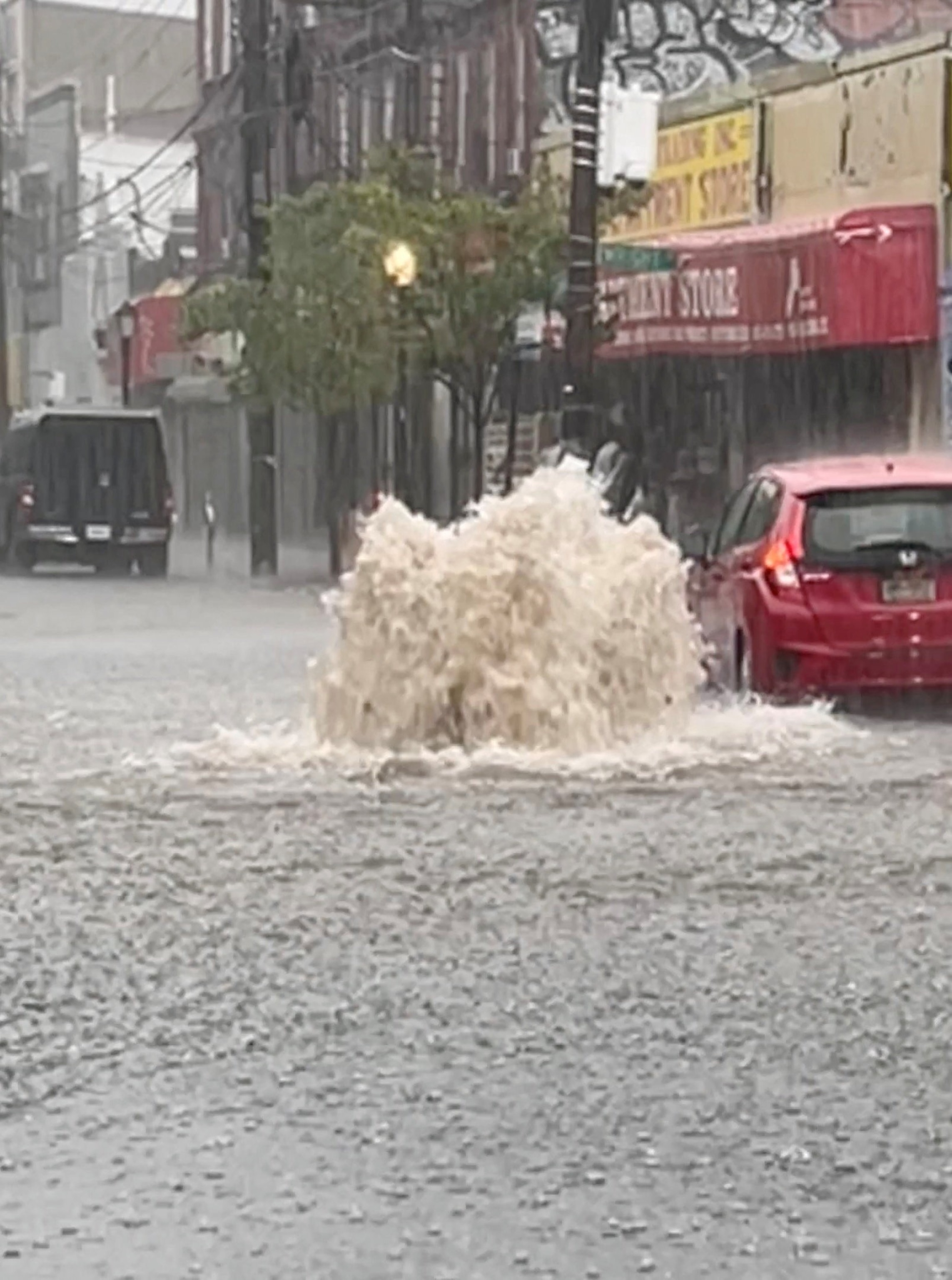 PHOTO: A car drives on a flooded street after heavy downpours in Staten Island, New York