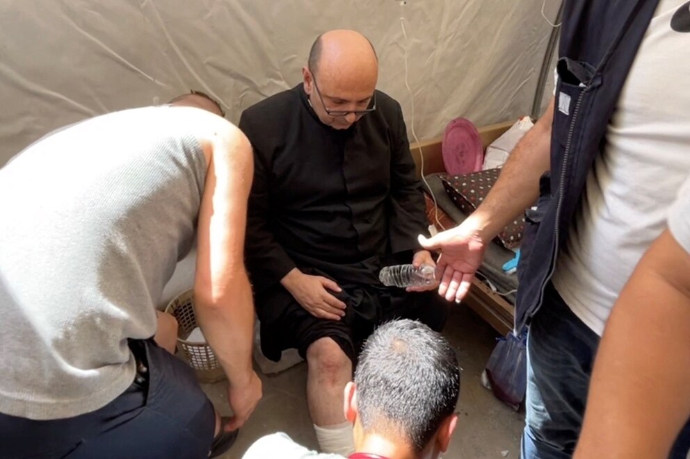 PHOTO: Parish priest of the Church of the Holy Family,  father Gabriele Romanelli, receives medical attention at Al-Ahli Arab Hospital in Gaza City, in this still image taken from a video July 17, 2025.