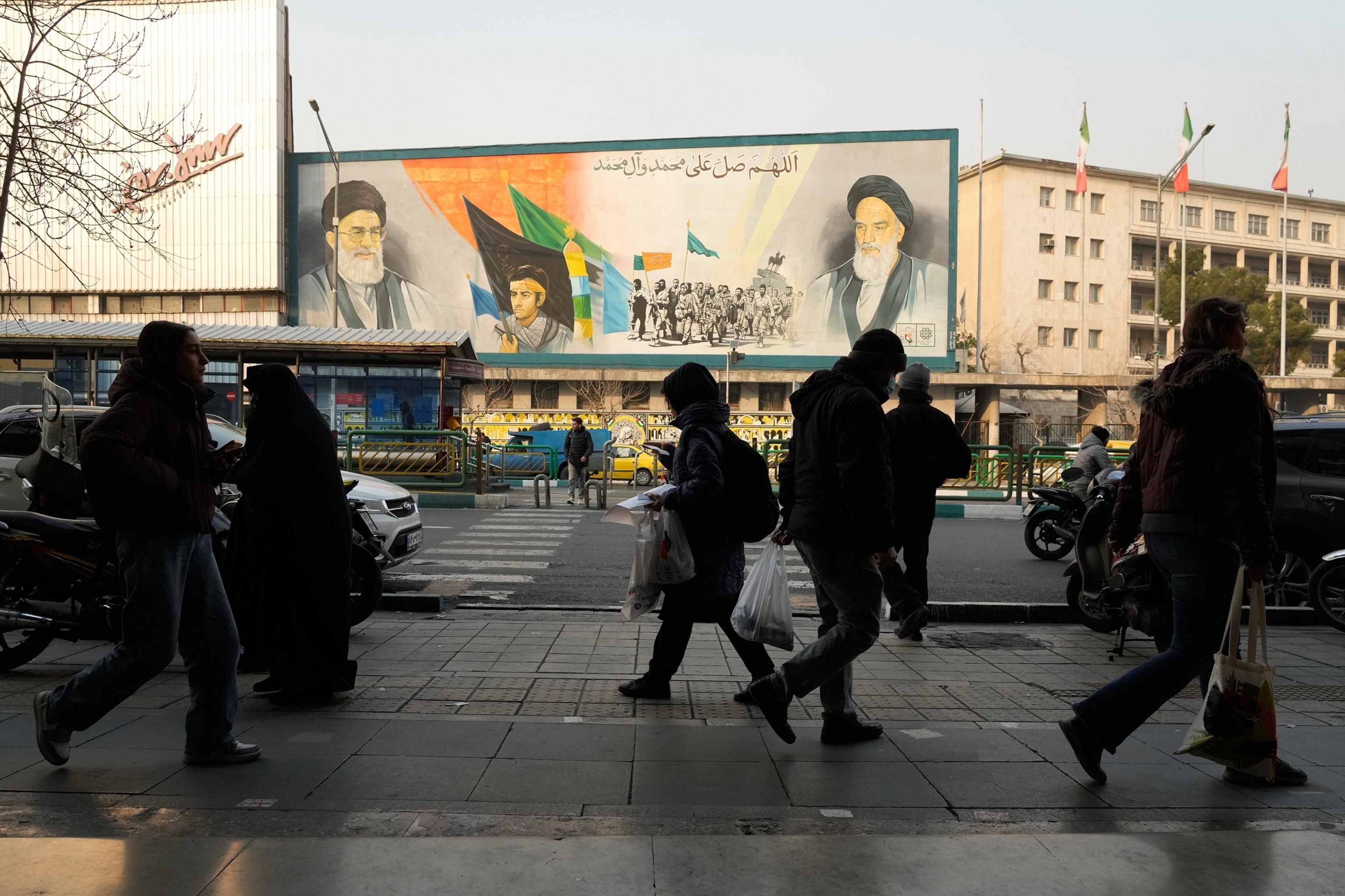 PHOTO: People walk in front of a mural depicting the late Iranian revolutionary founder Ayatollah Khomeini along Enqelab-e-Eslami (Islamic Revolution) Street in Tehran, Iran, Sunday, Jan. 25, 2026.