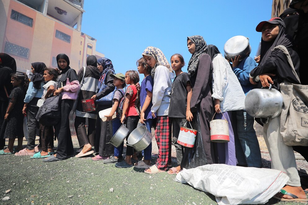 PHOTO: Hundreds of Palestinians struggling with hunger wait in line for hours under the scorching heat to receive food aid at Nuseirat Camp in Gaza Strip, on July 25, 2025. 