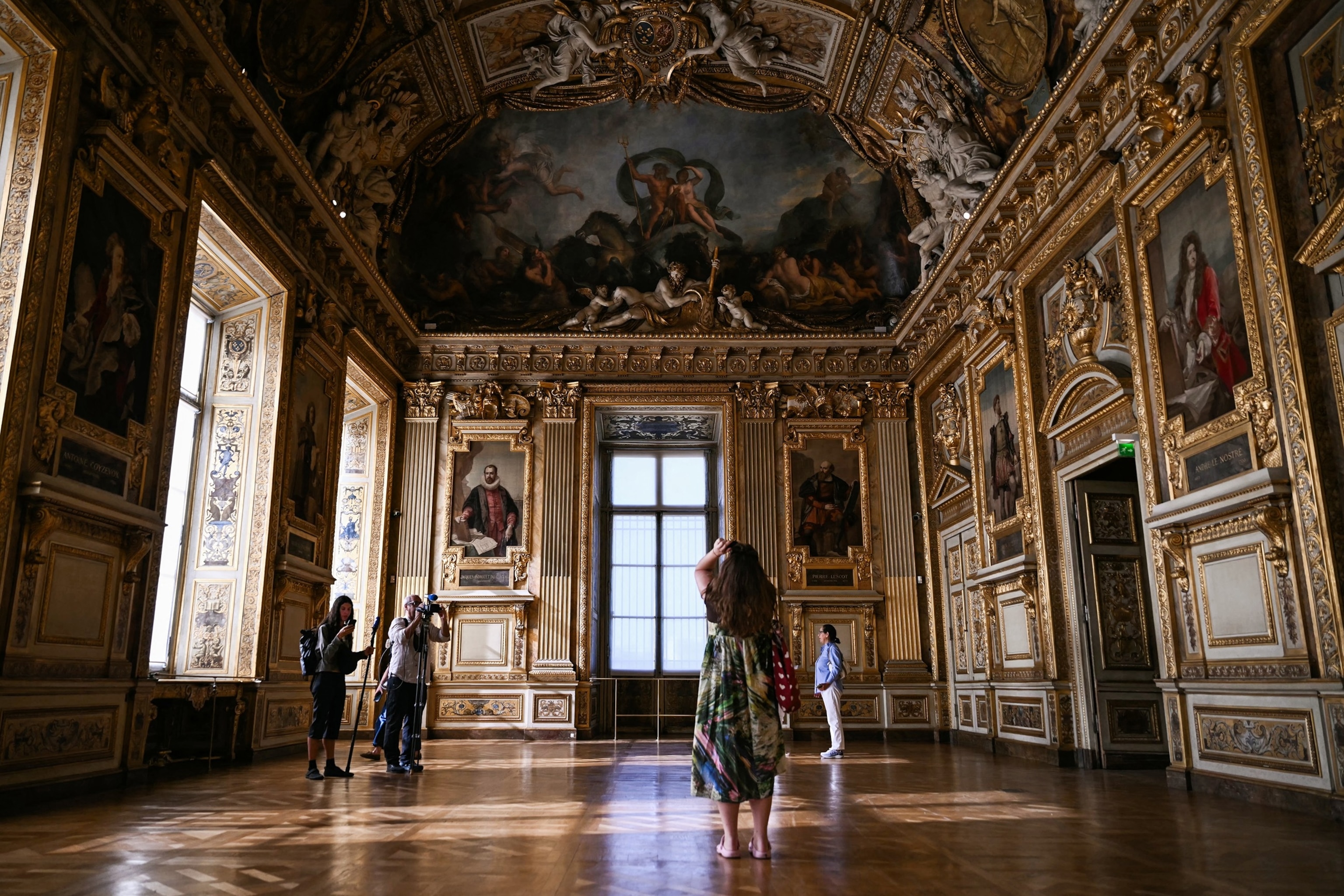 PHOTO: Visitors take a picture of the window which was broken during the reopening to the public of the Apollo Gallery, where French crown jewels were stolen in a 2025 heist, at the Musee du Louvre in Paris on July 22, 2026.