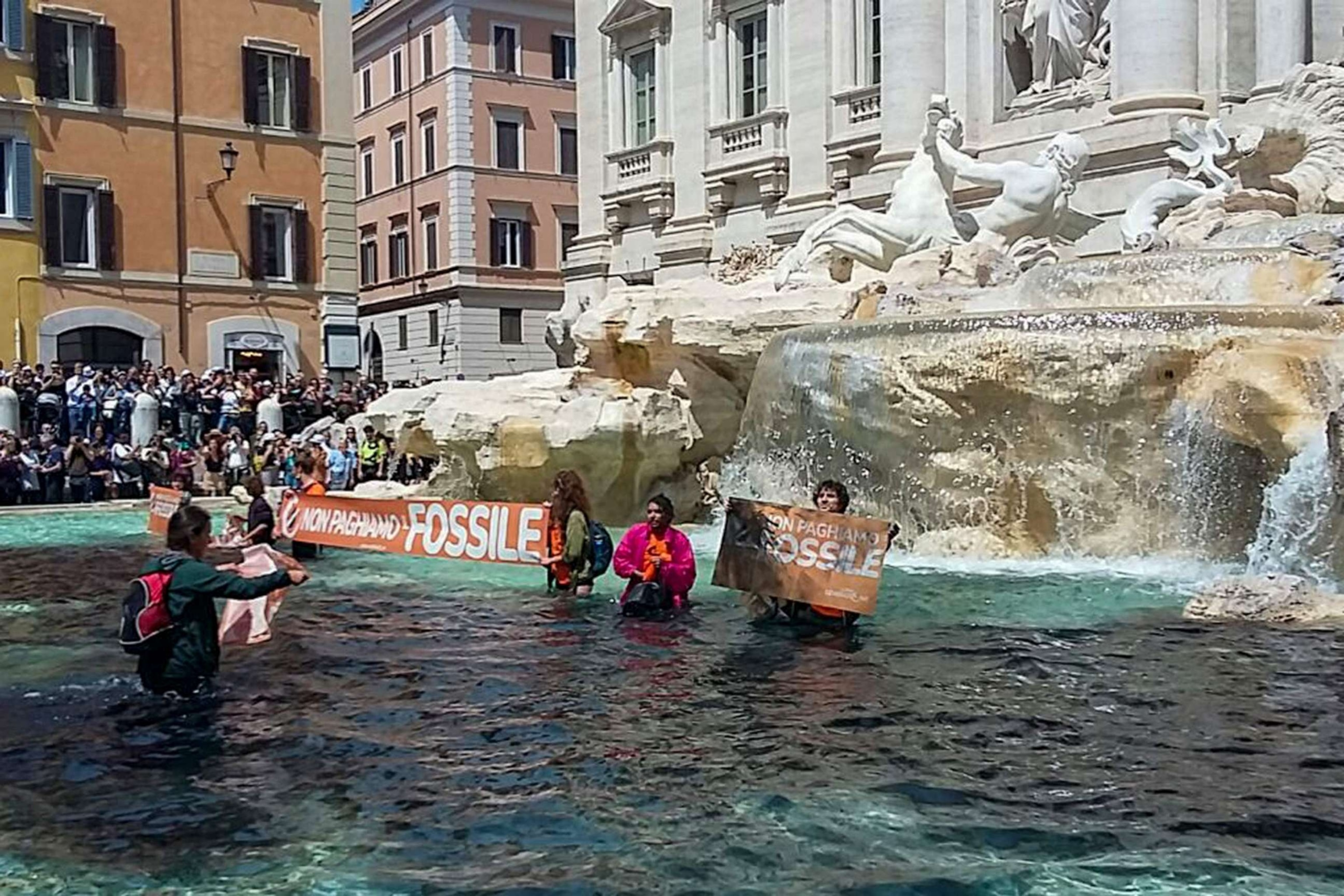 PHOTO: Environmental activists of Last Generation (Ultima Generazione) shows the group's activist holding a banner reading "we don't pay for the fossil" in Rome's historic Fontana di Trevi fountain, May 21, 2023.