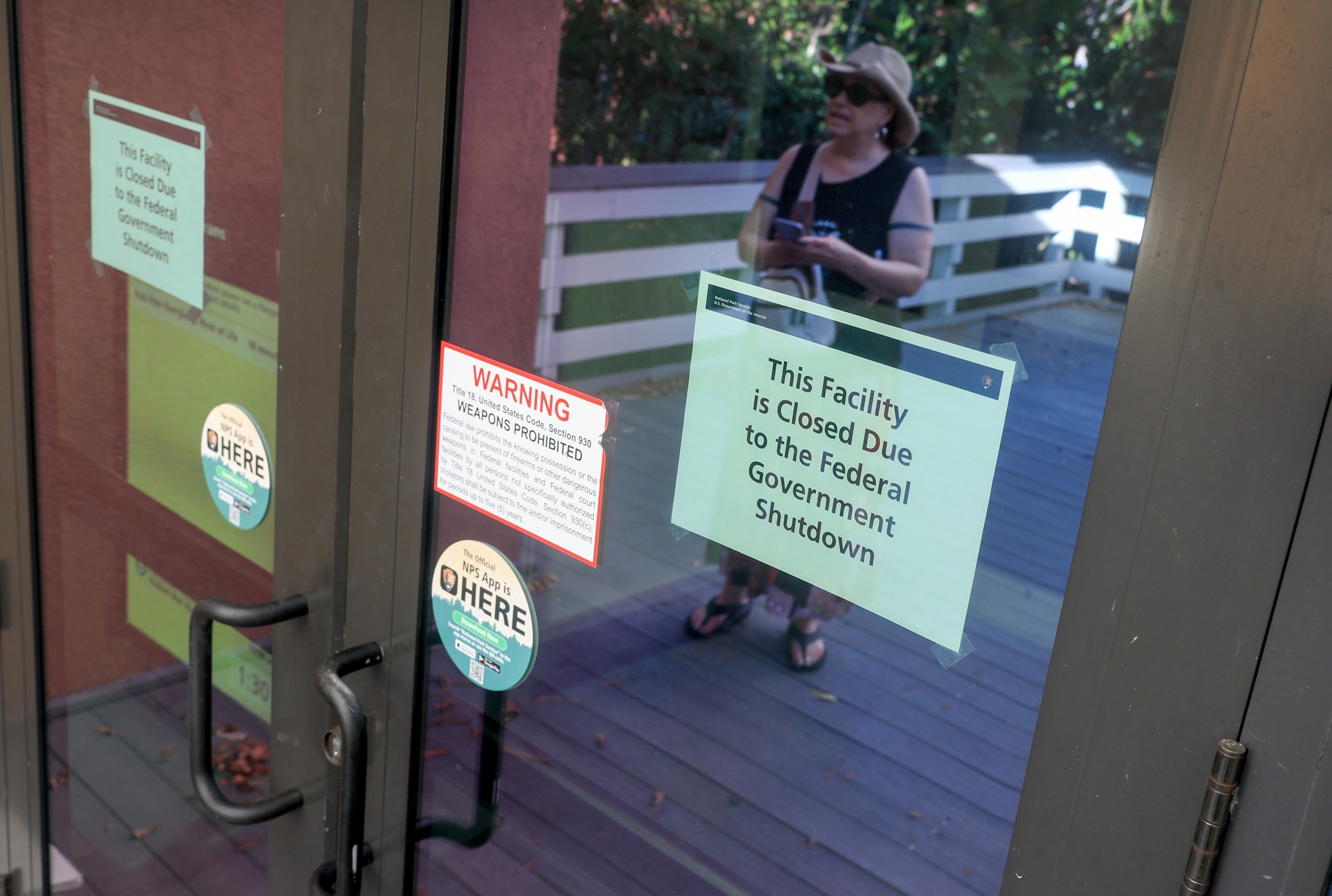 PHOTO: Susanne Brown looks at the sign that reads, ' This Facility is Closed Due to the Federal Government Shutdown', on the door to the Everglades National Park visitors center, Oct. 1, 2025, in Everglades National Park, Florida. 