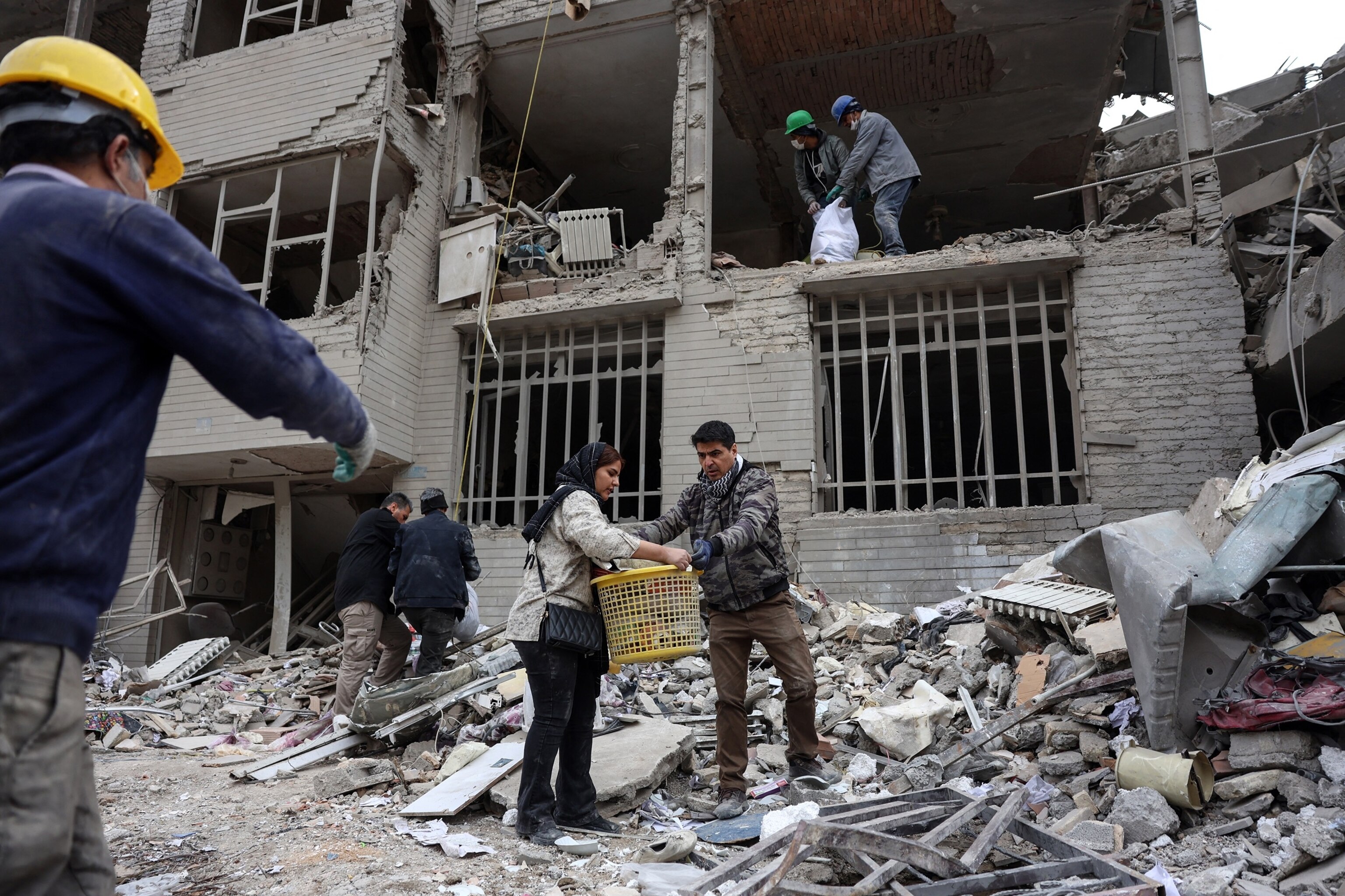 PHOTO: Iranians collect belongings from the rubble of a damaged residential building in Tehran on March 12, 2026. 