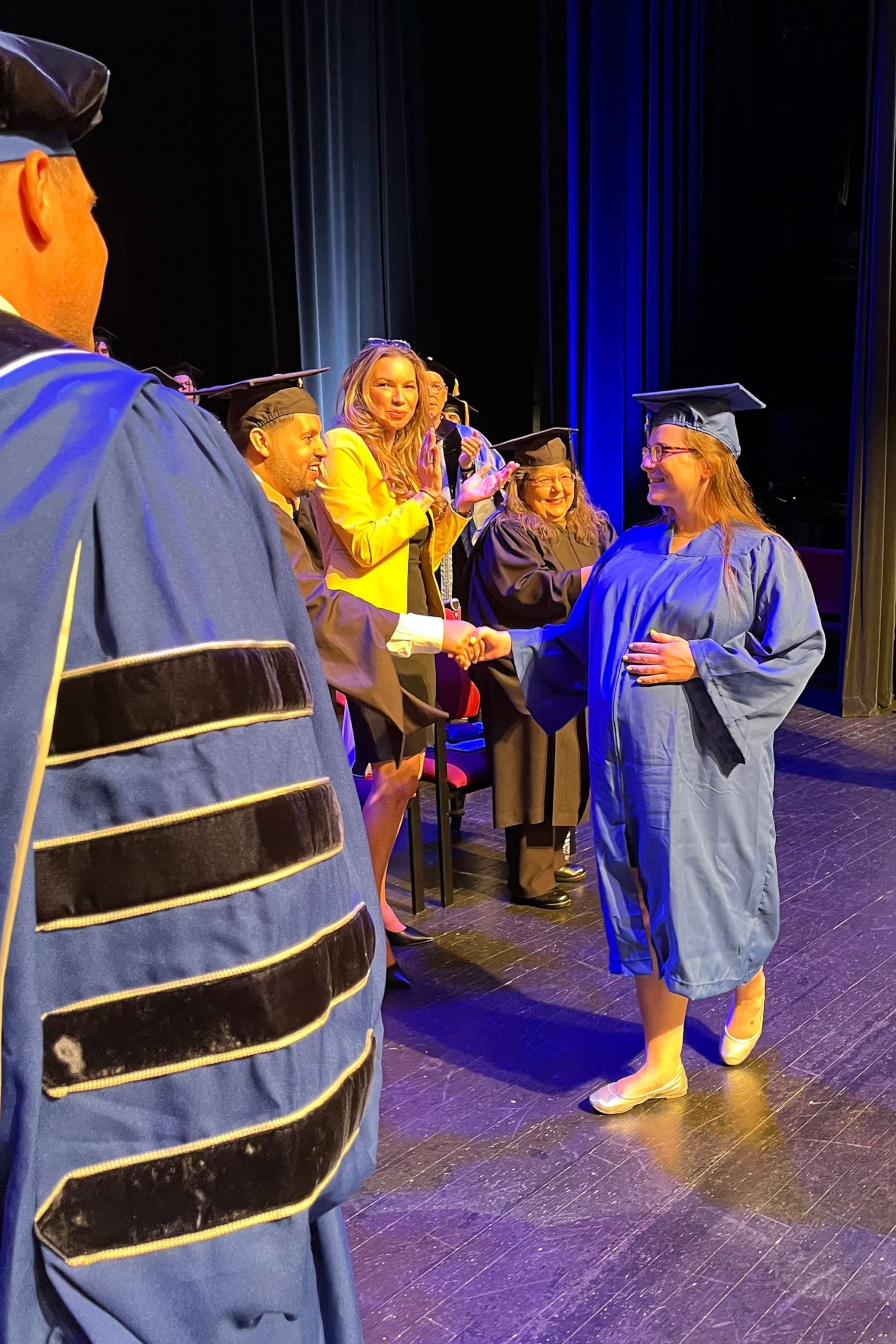 PHOTO: Kelsey Hudie holds her diploma alongside Russell Kavalhuna, the president of Henry Ford College.