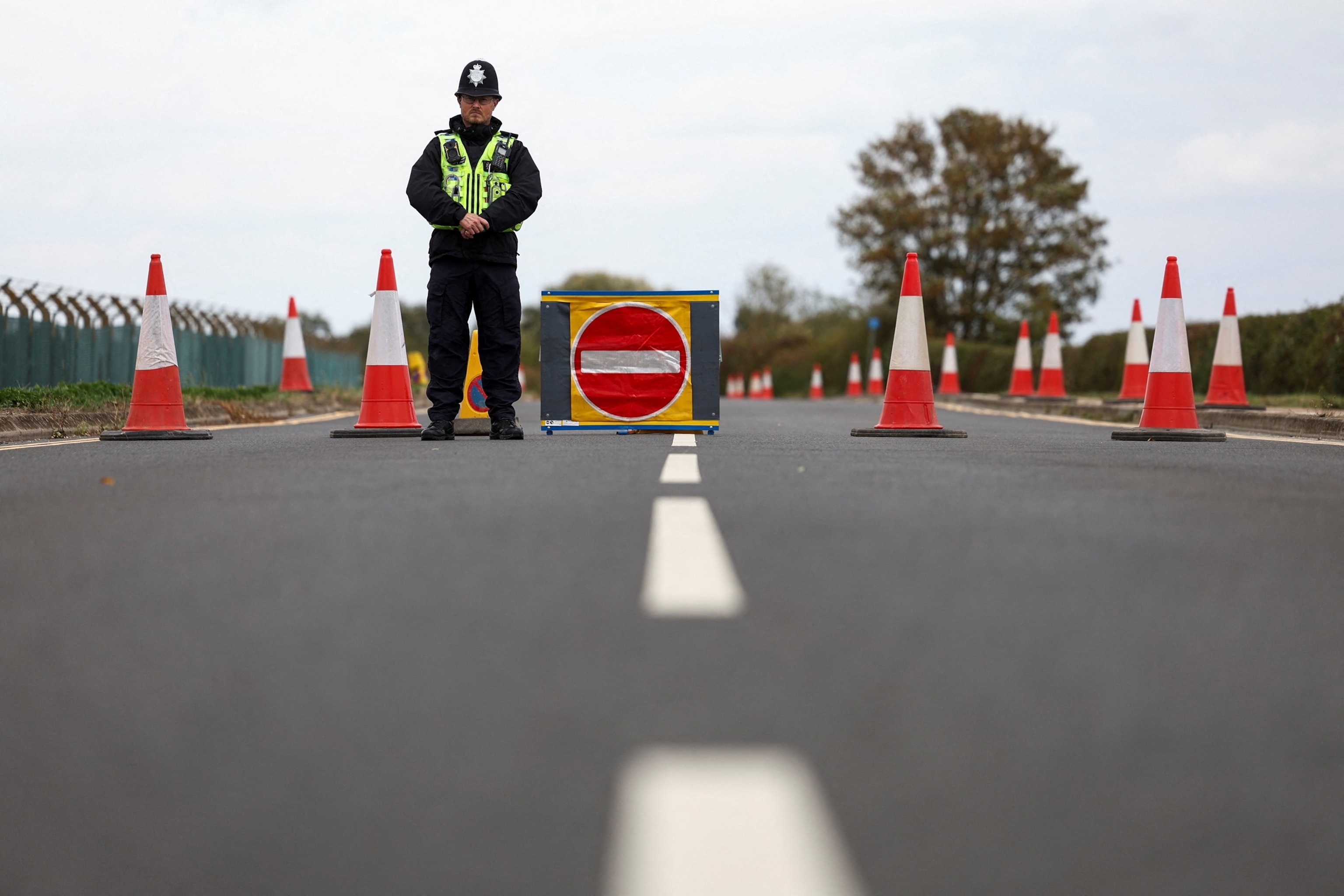 FOTO: Um policial monta guarda em uma estrada fechada fora do perímetro da base aérea RAF Fairford em Fairford, Gloucestershire, Grã-Bretanha, 27 de setembro de 2026. 