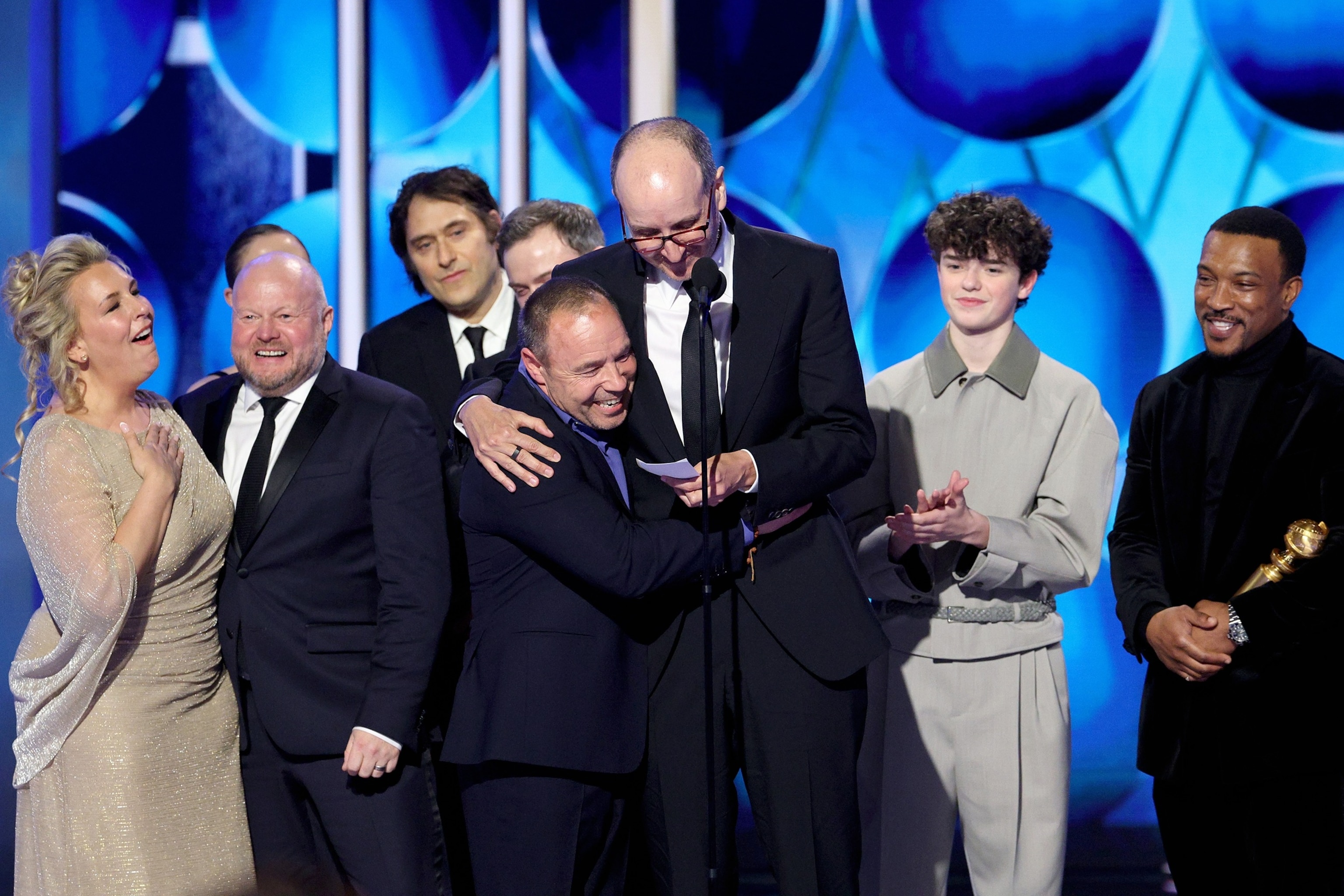 PHOTO: Hannah Walters, Mark Herbert, Jeremy Kleiner, Philip Barantini, Stephen Graham, Jack Thorne, Owen Cooper, and Ashley Walters accept the Best Limited Series, Anthology Series, or Motion Picture Made for Television Award for "Adolescence" onstage.