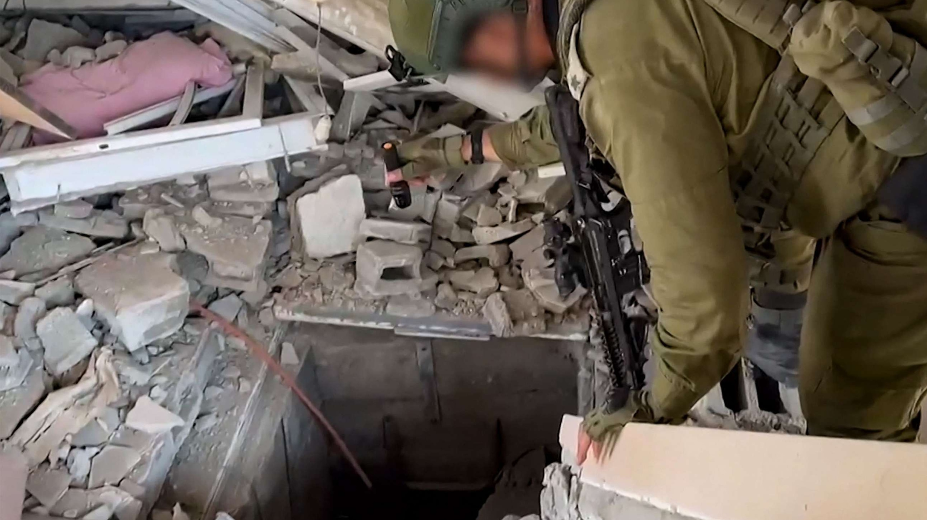 PHOTO: This screen grab taken from a handout footage released by the Israeli army, November 3, 2023, shows an Israeli soldier checking what it says is the entrance to a tunnel used by the Palestinian Hamas movement in the Gaza Strip.