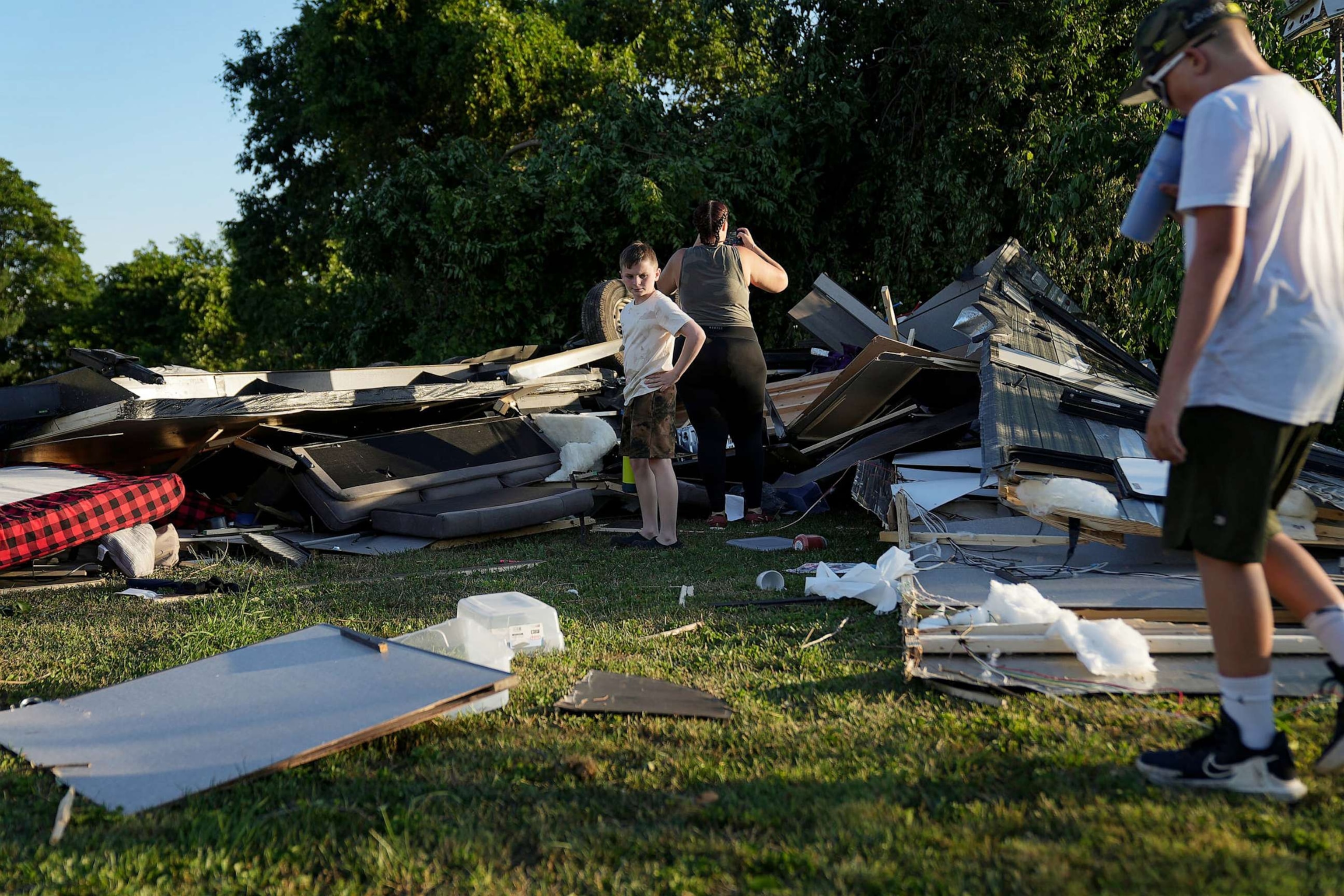 PHOTO: People survey what's left of an RV camper after a tornado touched down in several areas of Greenwood, Ind., June 25, 2023.