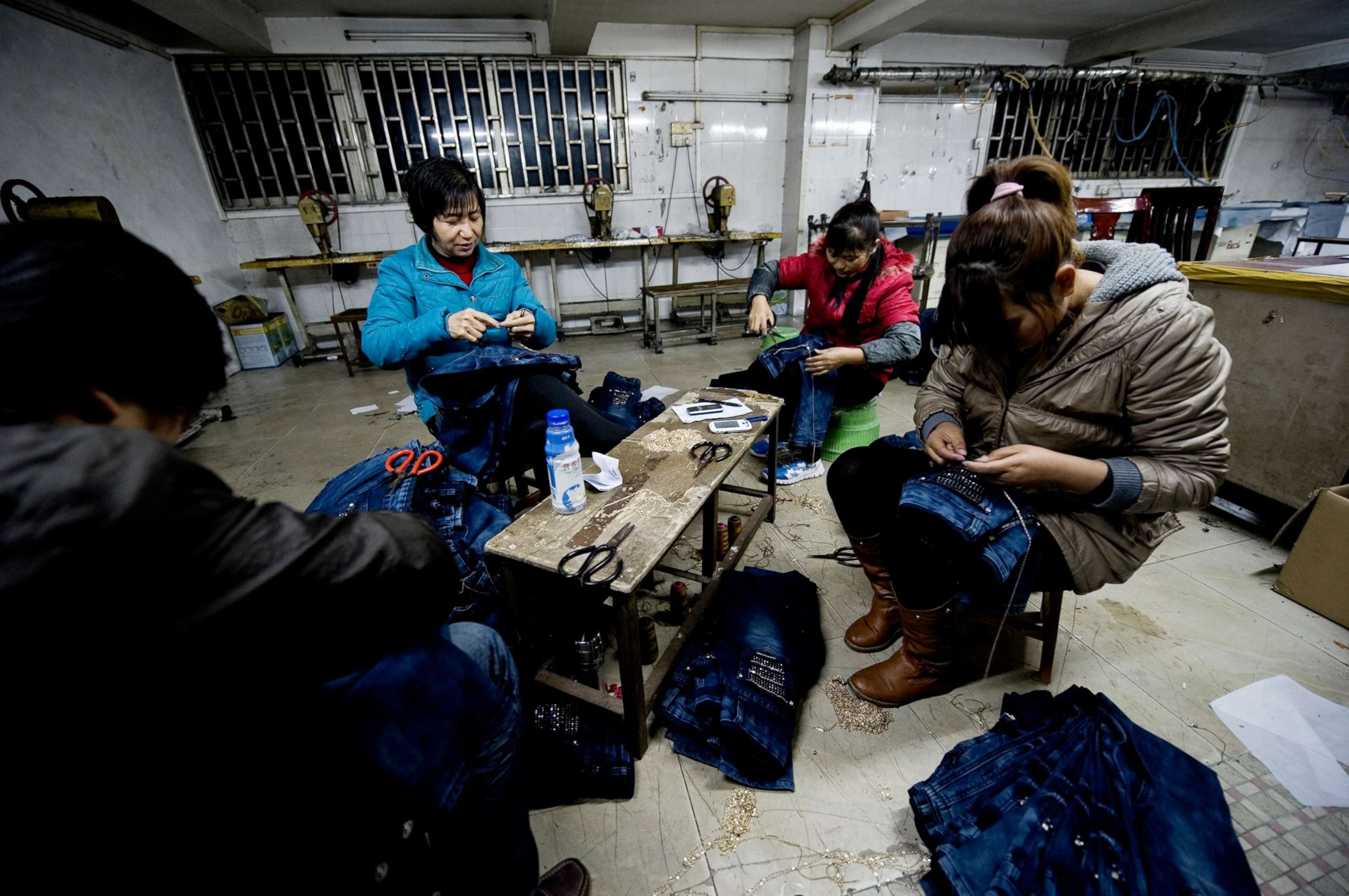 PHOTO: In this Feb. 10, 2012, file photo, workers sew blue jeans in a little workshop by the street, in Xintang, Guangdong province, China.