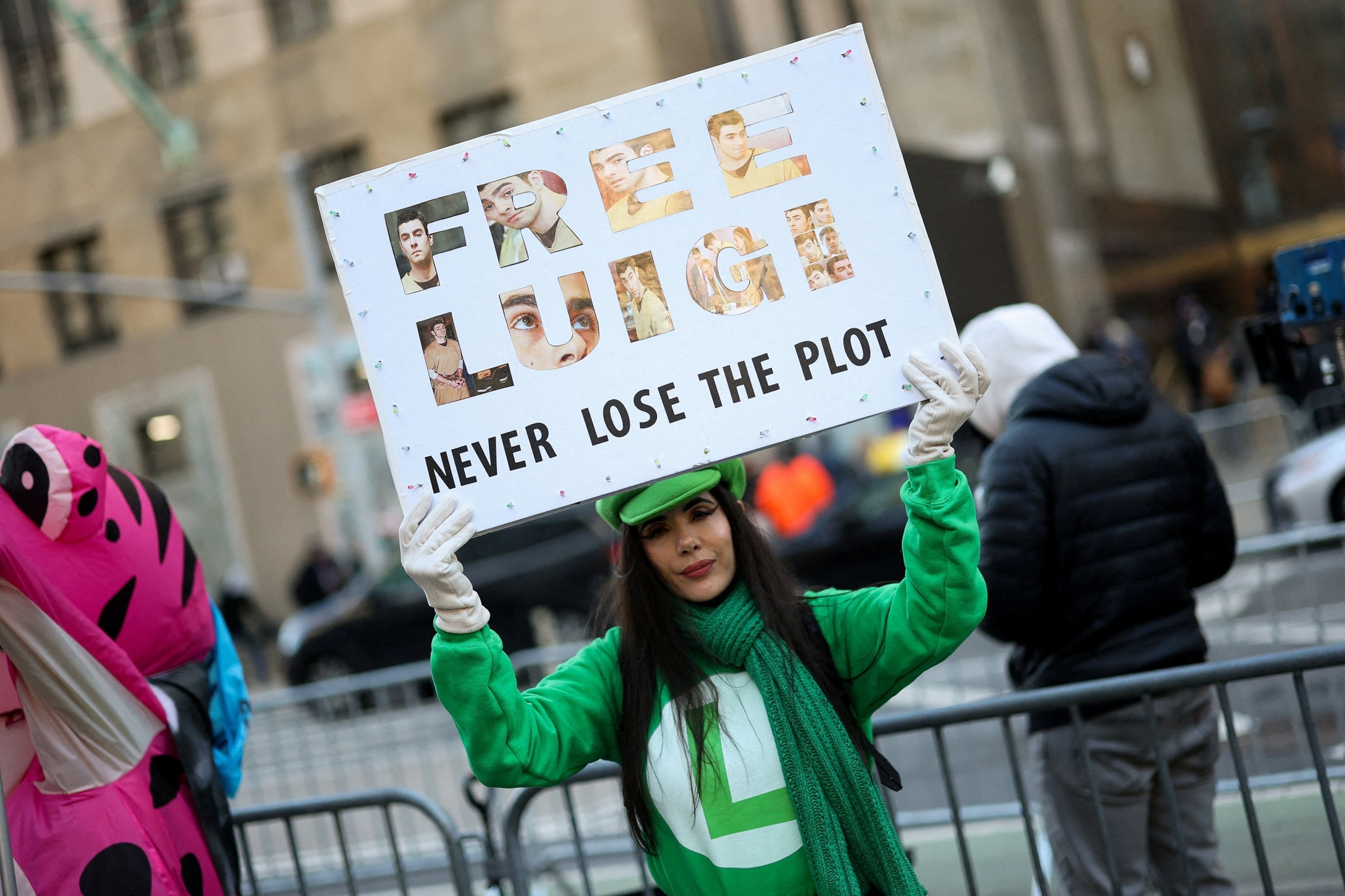 PHOTO: A supporter of Luigi Mangione, the suspect in the killing of UnitedHealthcare chief executive Brian Thompson, holds a sign outside Manhattan Criminal Court, ahead of his appearance for a pre-trial hearing in New York City, Dec. 1, 2025.