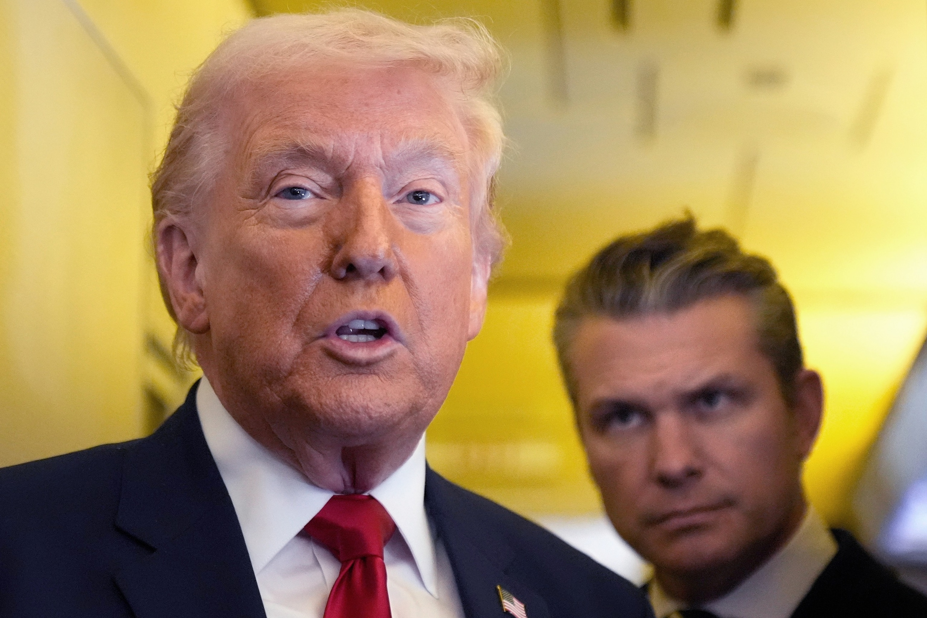 PHOTO: President Donald Trump speaks with the media as Defense Secretary Pete Hegseth looks on aboard Air Force One during a flight from Dover, Delaware, to Miami, Florida, March 7, 2026. 