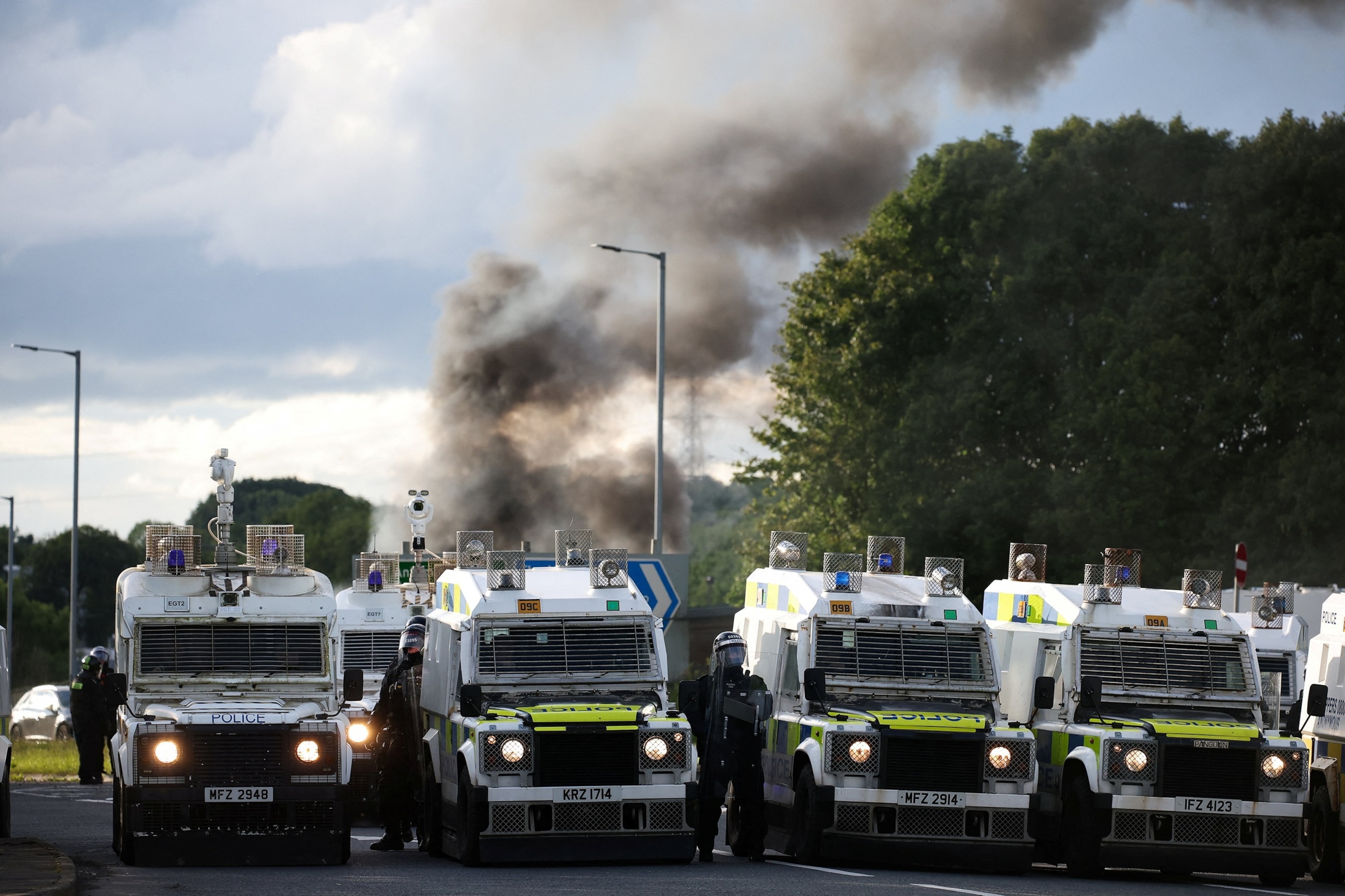 PHOTO: Smoke rises, as police stand by vehicles, as they control anti-immigrant protesters in Belfast, Northern Ireland, June 10, 2026. 