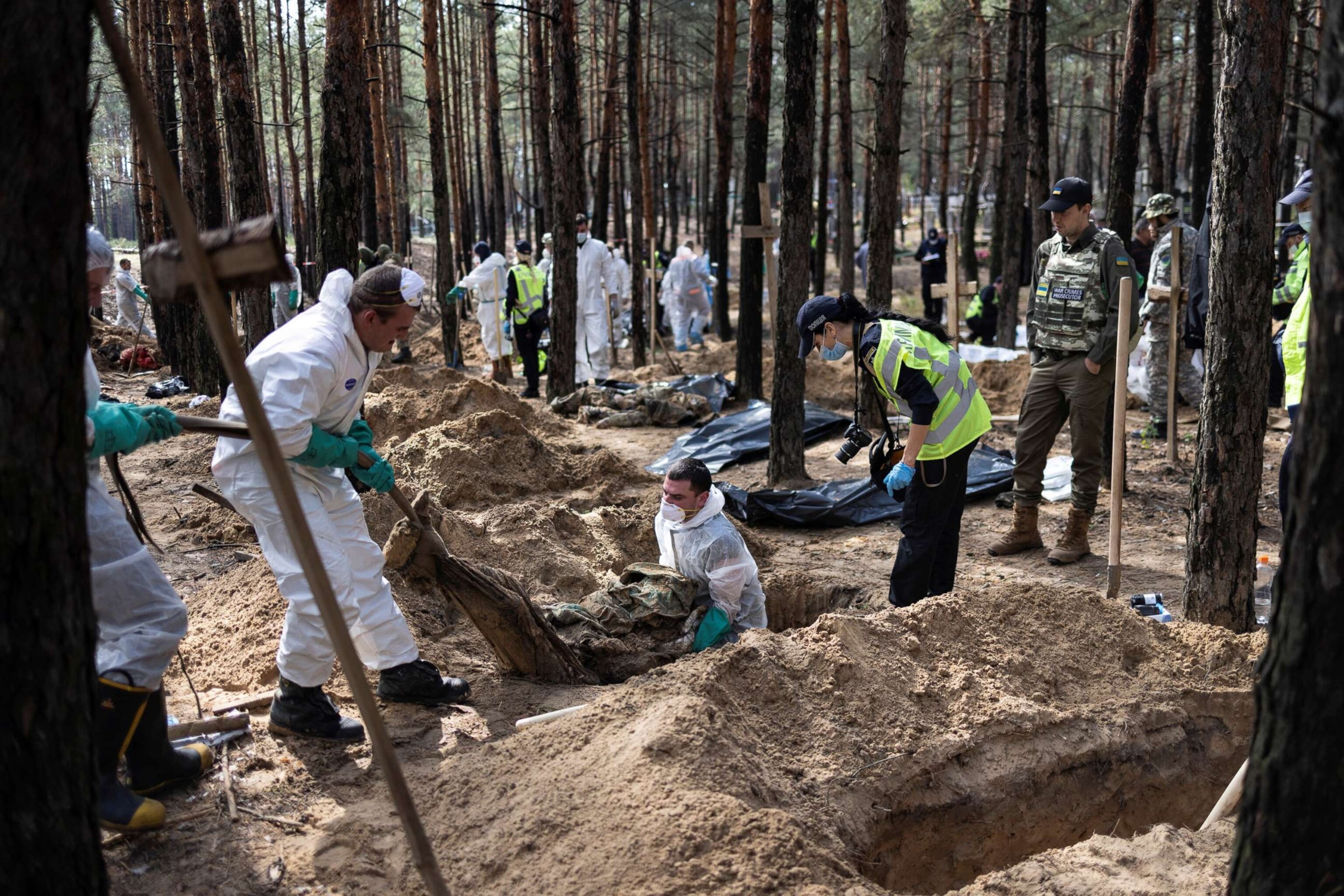 PHOTO: Experts work at a forest grave site during an exhumation in the town of Izium, recently liberated by Ukrainian Armed Forces, in Kharkiv region, Ukraine, Sept. 18, 2022.