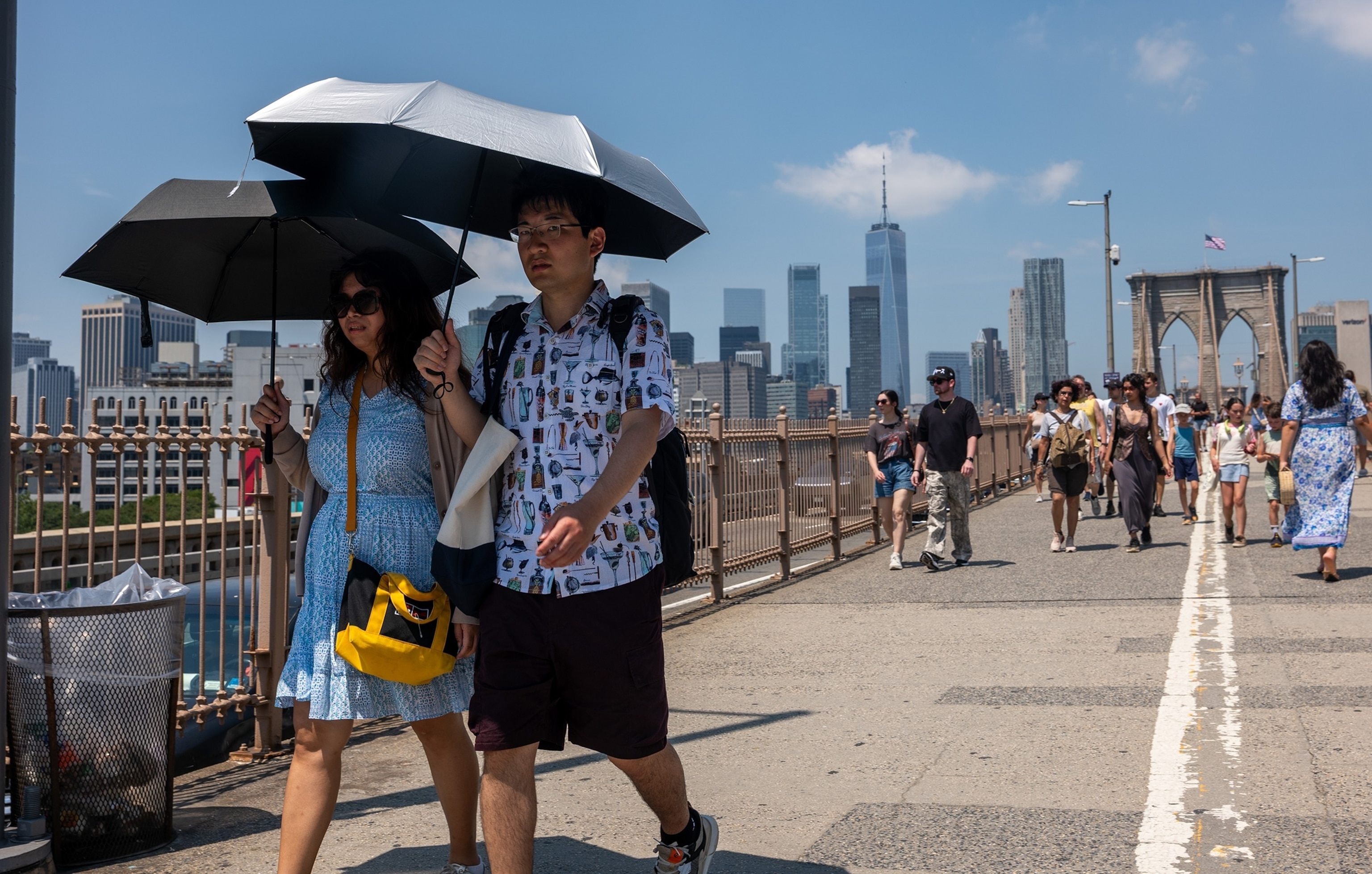 PHOTO: People walk across the Brooklyn Bridge in New York on a day where the heat index topped 100 degrees, July 25, 2025.