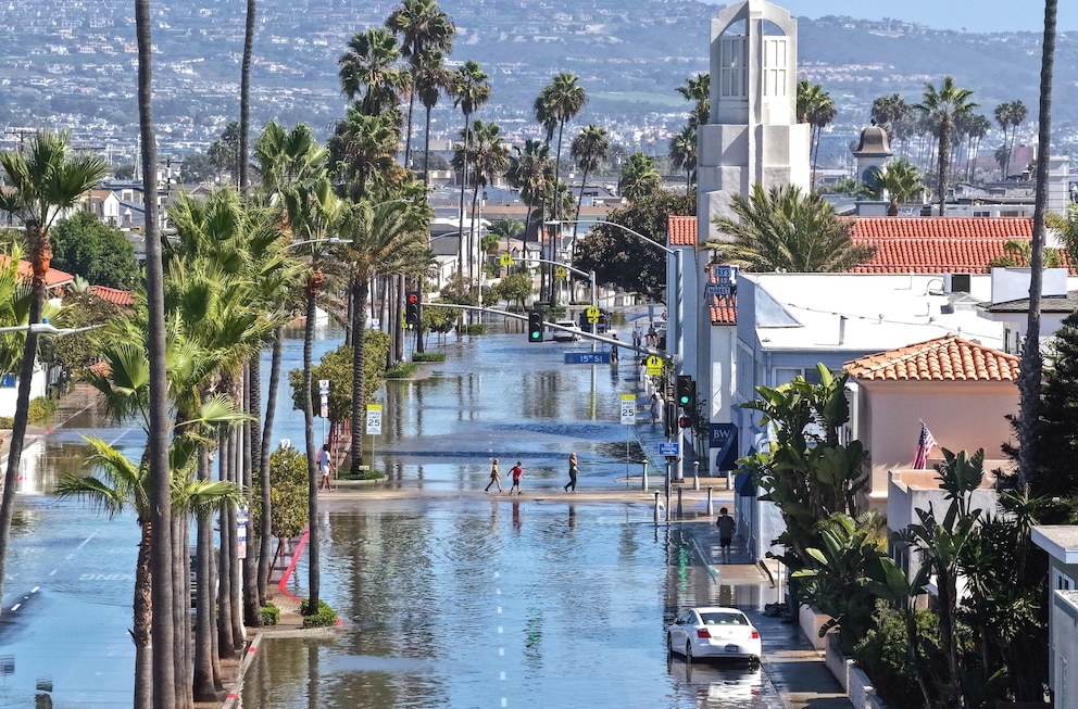 PHOTO: In an aerial view, people walk near coastal floodwaters amid strong waves and high tides generated by Tropical Storm Rachel, October 9, 2026, in Newport Beach, California. 