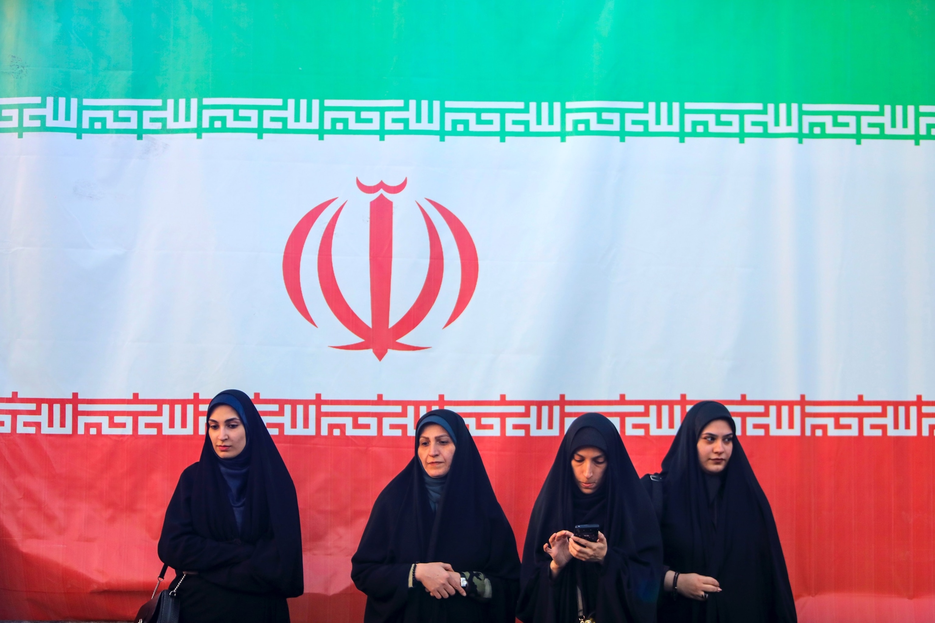 PHOTO: Women seen in front of an Iranian flag  during a pro-government National Army Day demonstration on April 17, 2026 in Tehran, Iran.