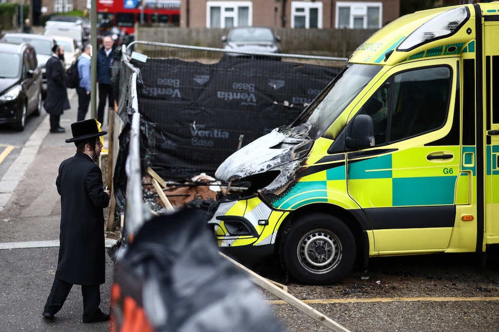 PHOTO: A member of the Jewish community views the scene of an antisemitic arson attack through a makeshift fence in the Golders Green neighbourhood, on March 24, 2026, a day after volunteer ambulances run by a Jewish organisation were set on fire.
