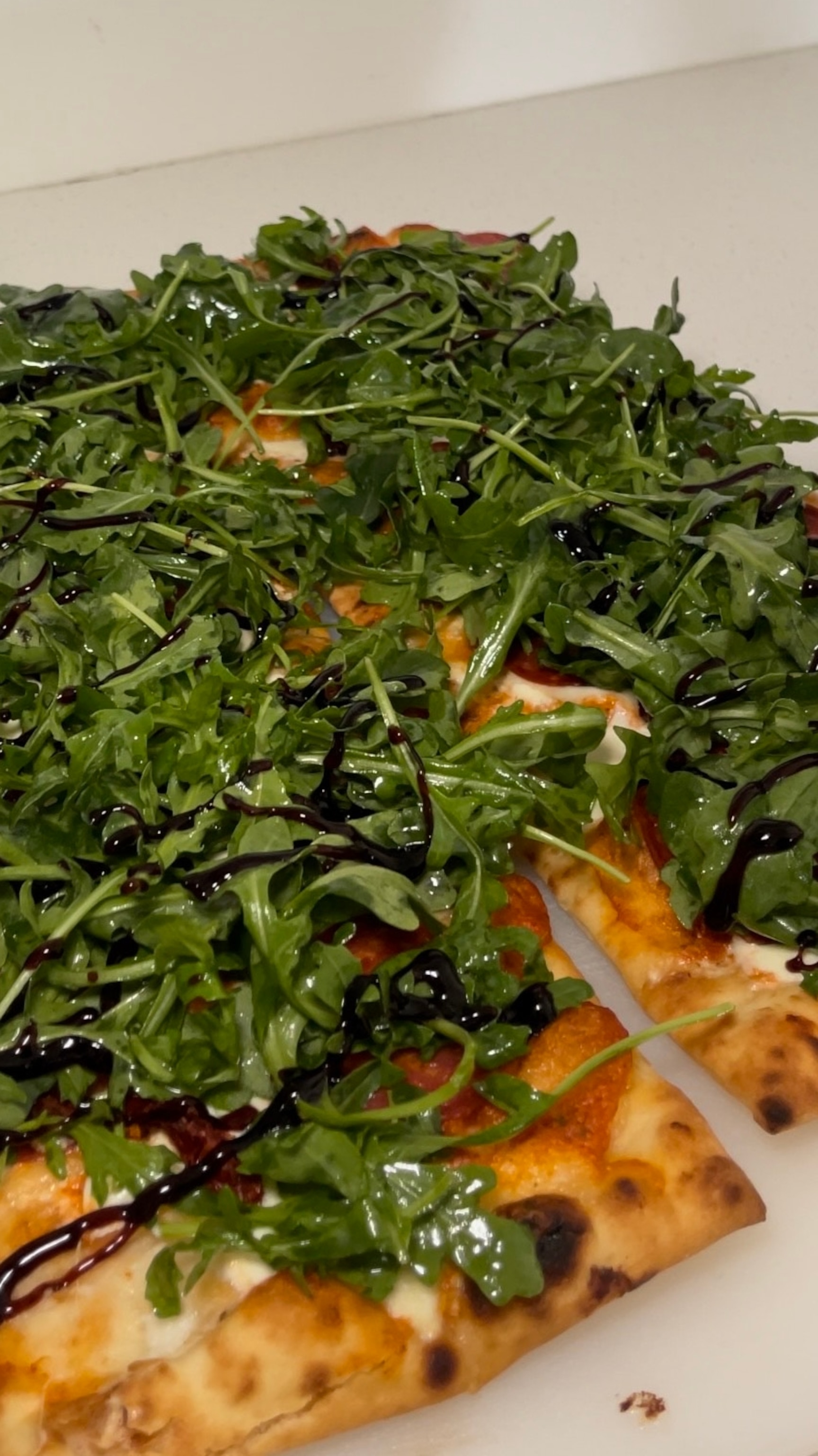 PHOTO: A homemade spicy pizza topped with arugula using Trader Joe's ingredients.