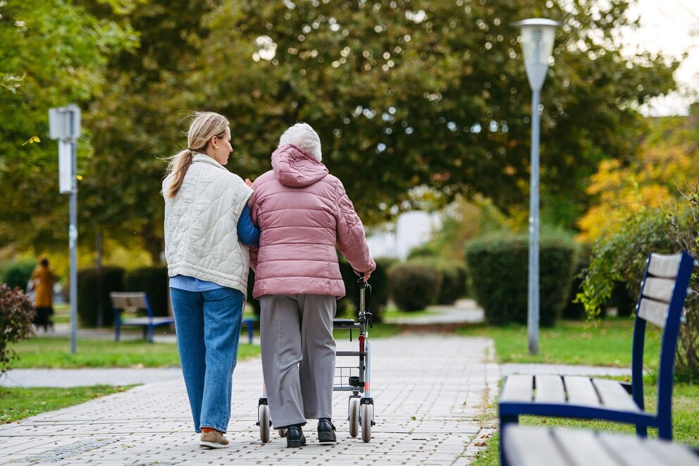 PHOTO: Rear view of senior woman and her home caregiver spending a chilly, windy day outdoors in city park.