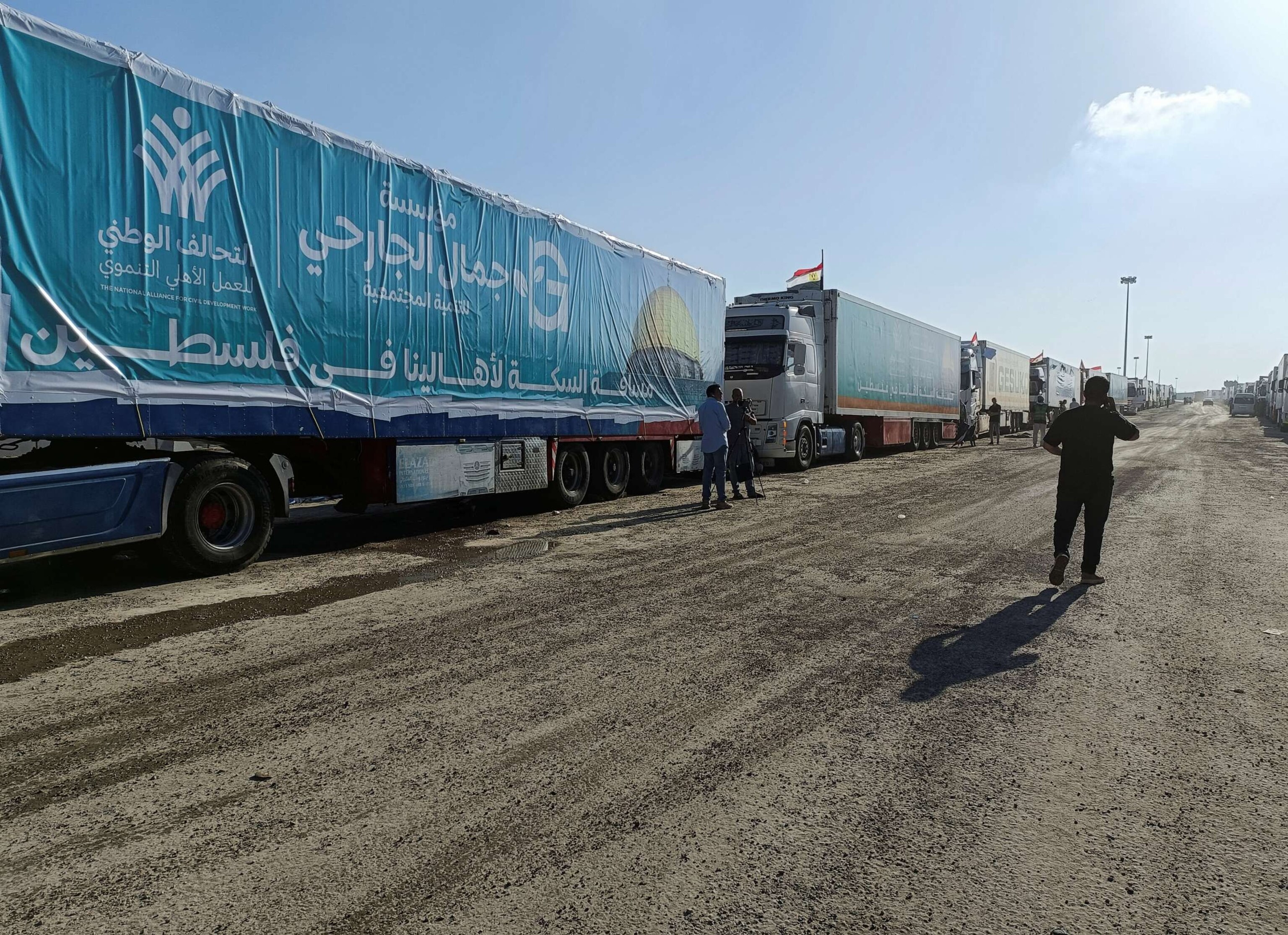 PHOTO: An Egyptian volunteer walks next to trucks carrying humanitarian aid from Egyptian NGOs for Palestinians, as they await for the reopening of the Rafah crossing at the Egyptian side to enter Gaza, in Rafah, Egypt, Oct. 19, 2023.