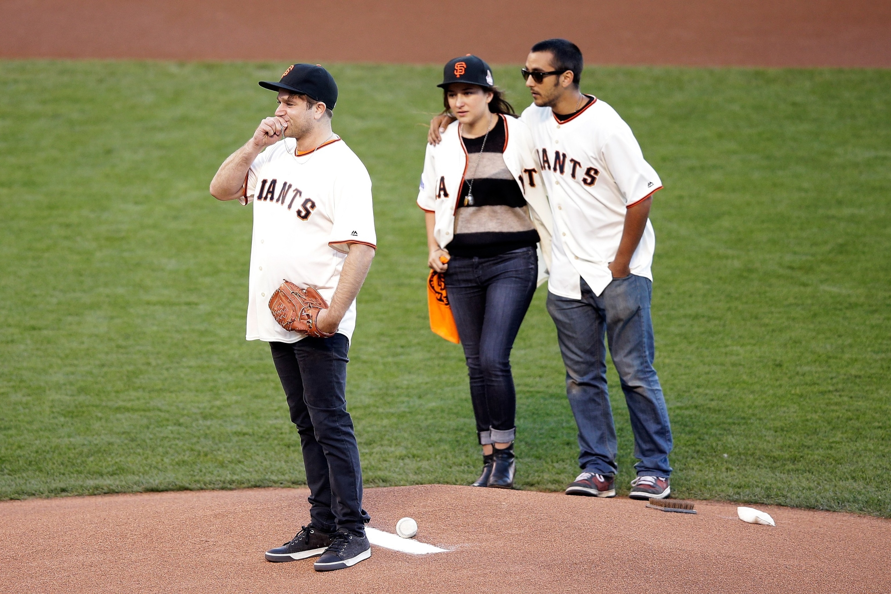 PHOTO: Zak Williams, son of Robin Williams, throws out the ceremonial first pitch as Zelda and Cody Williams look on before Game Five of the 2014 World Series between the San Francisco Giants and the Kansas City Royals at AT&T Park on October 26, 2014.