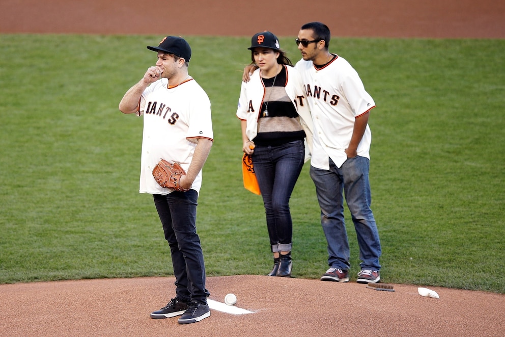 PHOTO: Zak Williams, son of Robin Williams, throws out the ceremonial first pitch as Zelda and Cody Williams look on before Game Five of the 2014 World Series between the San Francisco Giants and the Kansas City Royals at AT&T Park on October 26, 2014. 