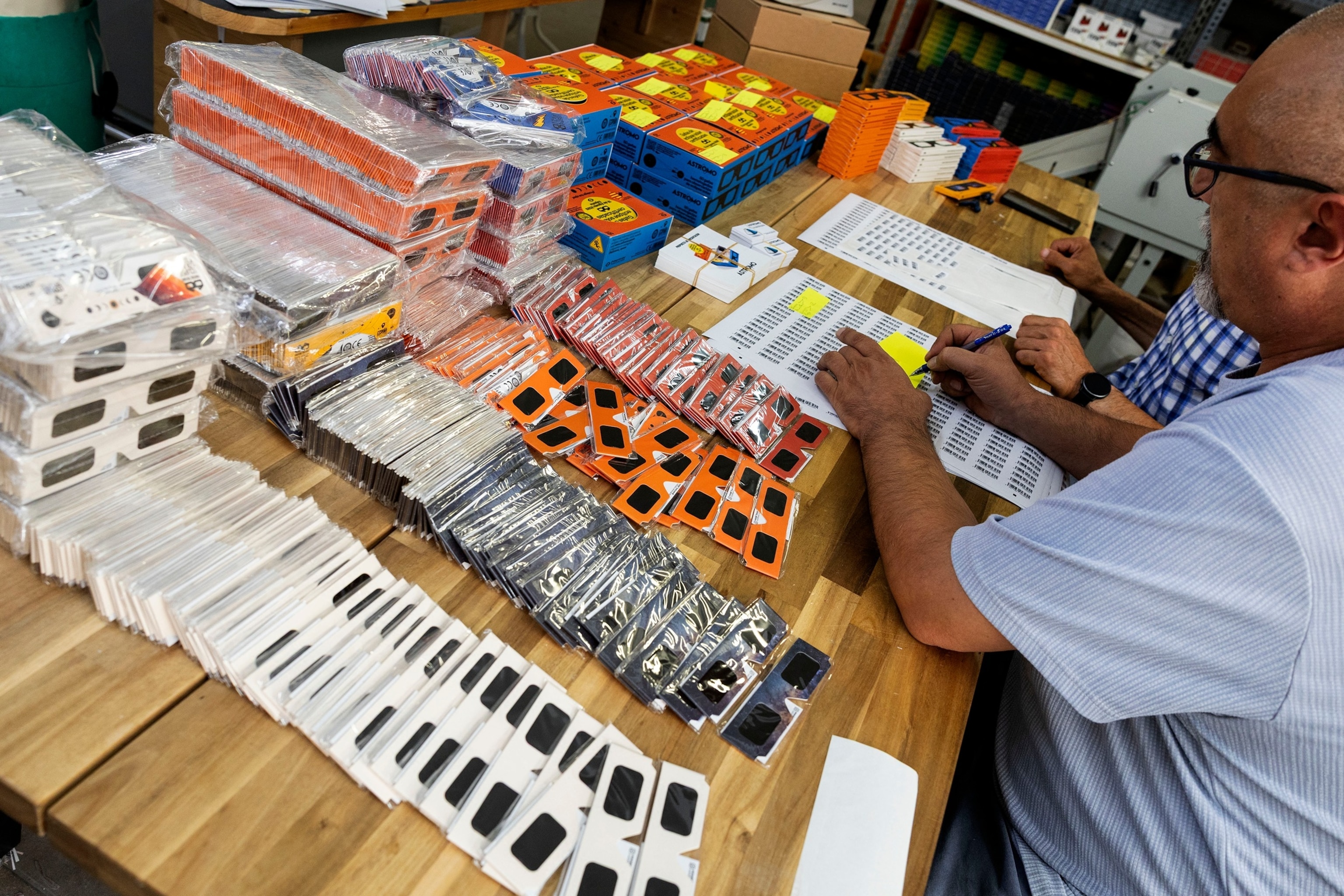 PHOTO: Workers at Astromo package eclipse viewing glasses certified with the  ISO 12312-2:2015 international safety standard which specifies requirements for direct observation of the sun, in Palma de Mallorca, June 25, 2026.