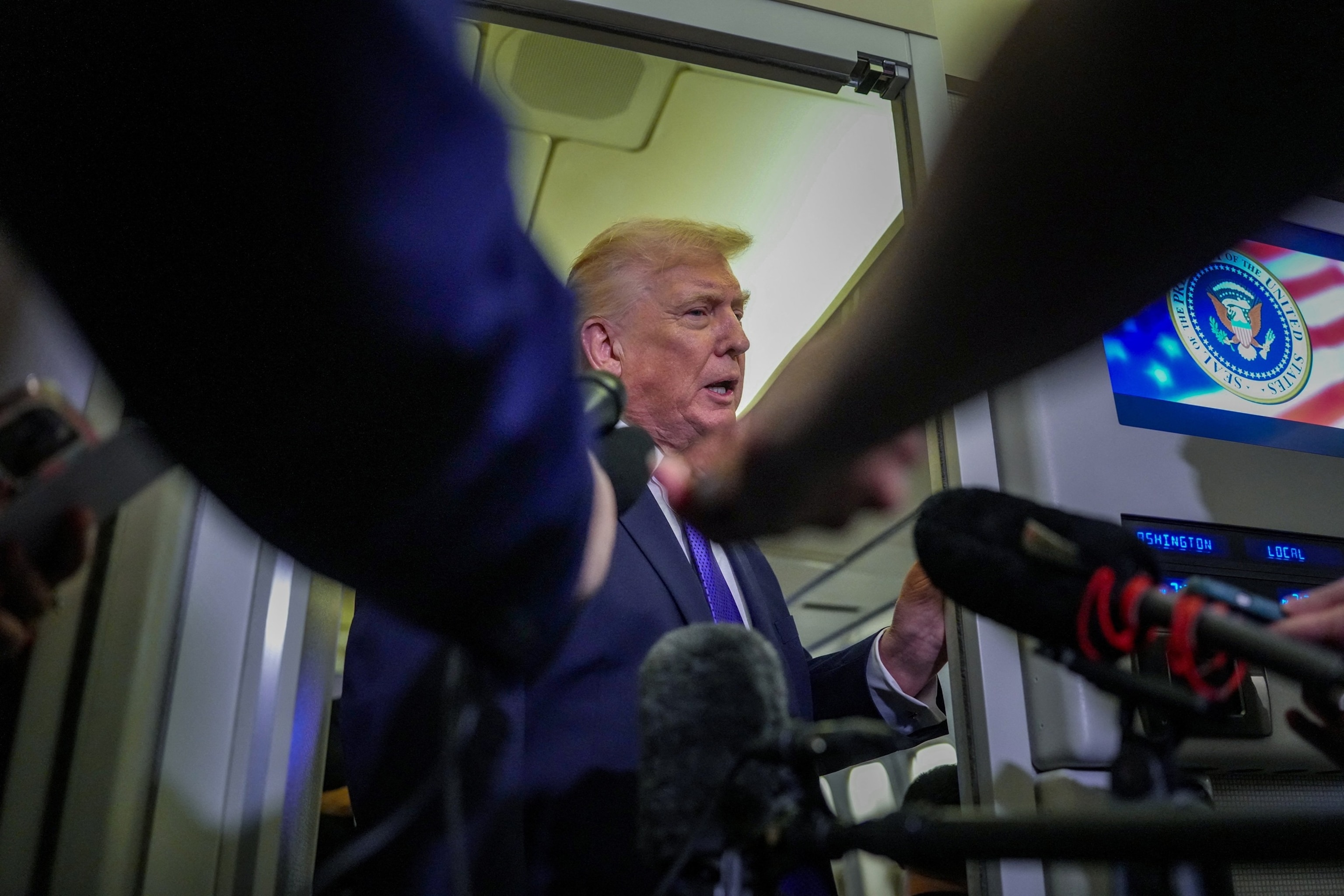 PHOTO: U.S. President Donald Trump speaks with members of the media on board Air Force One