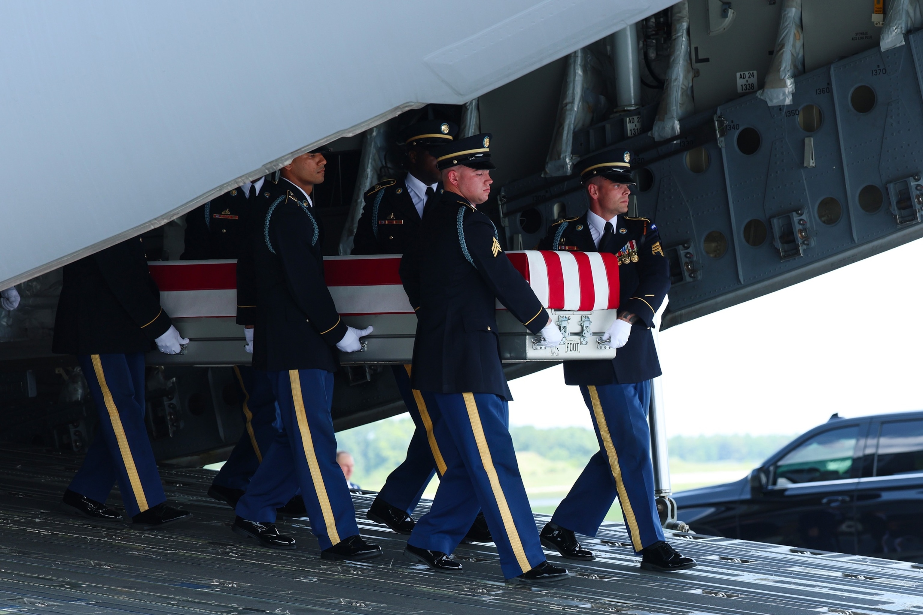 PHOTO: Members of a U.S. Army carry team move the flag-draped transfer case holding the remains of Army Staff Sgt. Michael Emmanuel Swinton of Fayetteville, during a dignified transfer at Dover Air Force Base July 22, 2026 in Dover, Delaware. 