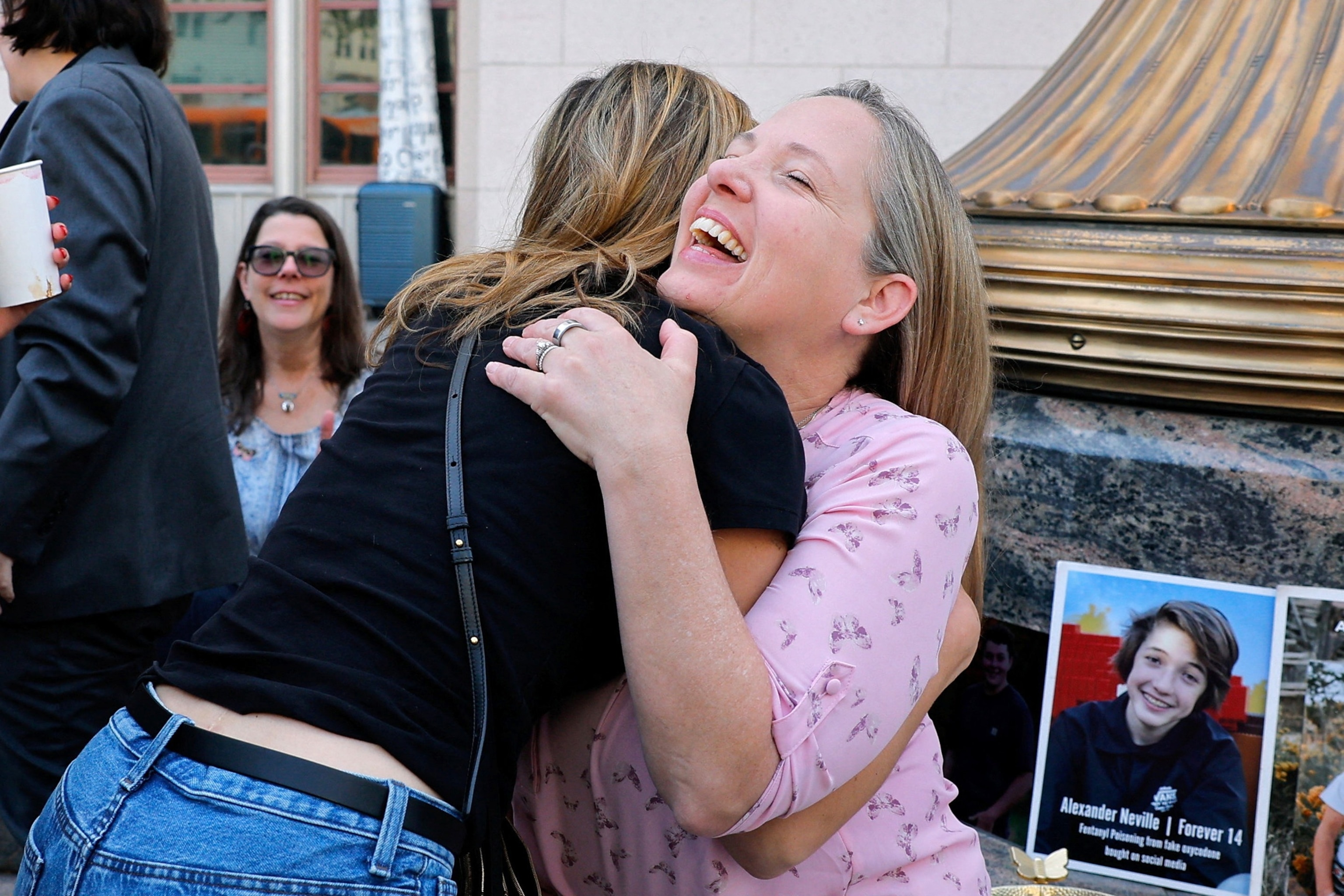 PHOTO: Amy Neville, mother of Alexander, is embraced outside the court as she awaits the verdict in case accusing Meta and Google's YouTube of harming children's mental health through addictive social media platforms, in Los Angeles, on March 25, 2026.