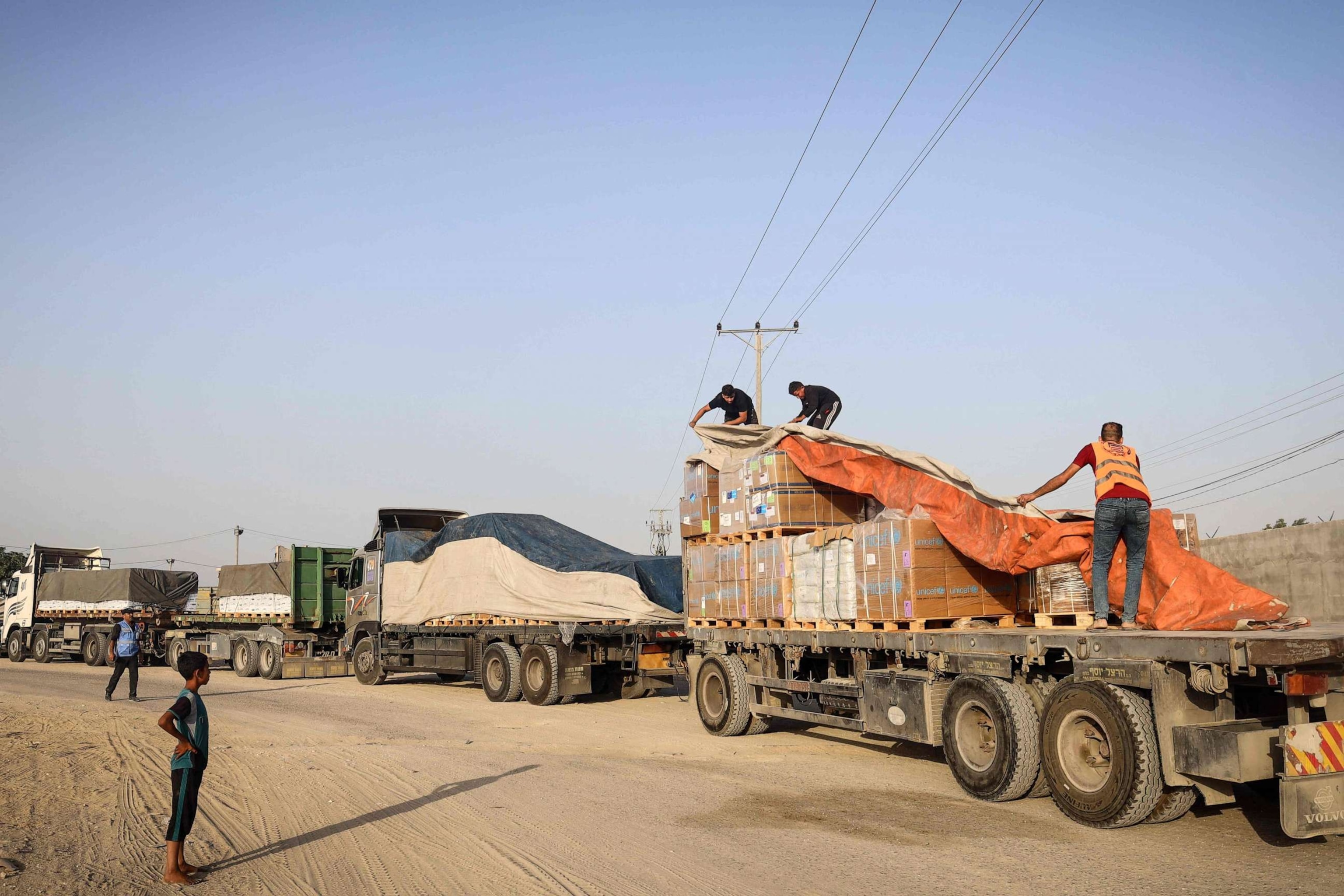 PHOTO: People unload humanitarian aid on a convoy of lorries entering the Gaza Strip from Egypt via the Rafah border crossing on Oct. 21, 2023.