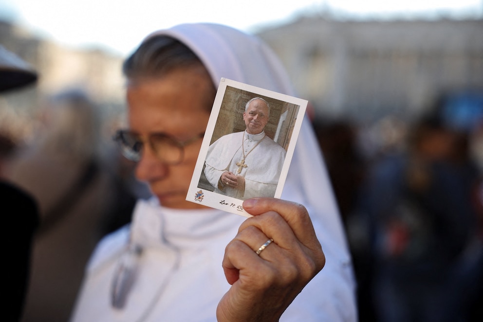 PHOTO: A person holds a picture of Pope Leo in St. Peter's Square at the Vatican, October 14, 2026.