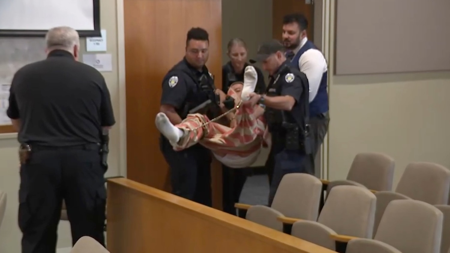 Court officers carry a shackled Daniel Jones, charged in the fatal shooting of his father and stepmother, into a court hearing, October 29, 2026, in Oberlin, Ohio. WEWS