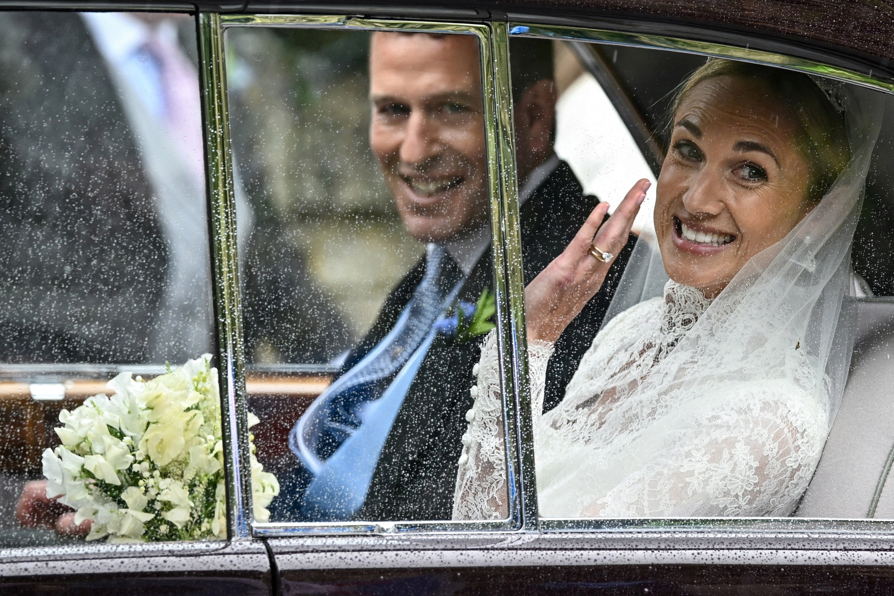 PHOTO: Harriet Sperling waves from a vehicle as she sits with Peter Phillips, on the day of their wedding at All Saints' Church in Kemble, Cirencester, Britain, June 6, 2026. 