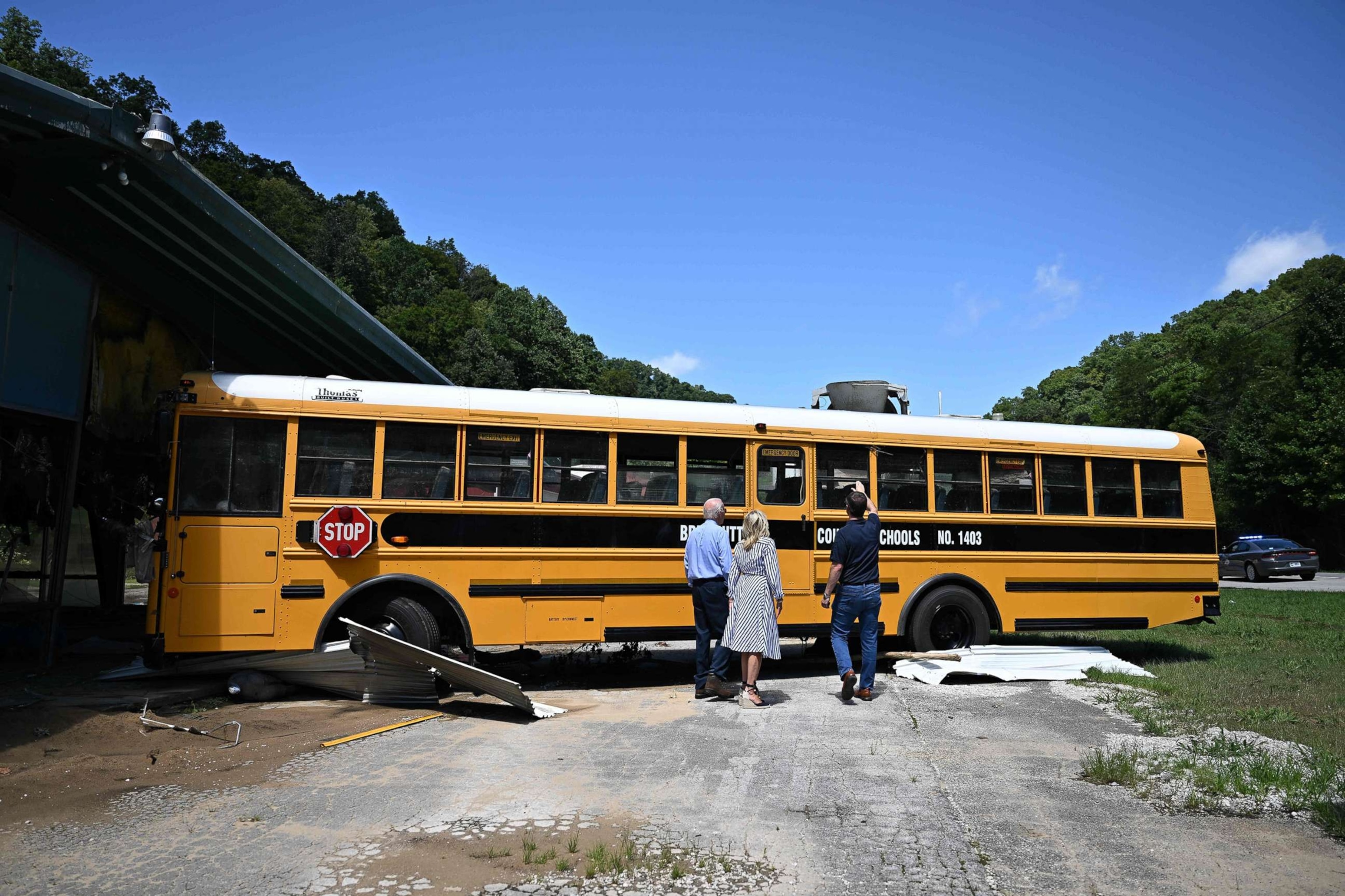 PHOTO: President Joe Biden, First Lady Jill Biden, and Andy Beshear, Governor of Kentucky, look at a bus that was swept away by flood waters as they survey damage in Lost Creek, Ky., on Aug. 8, 2022.