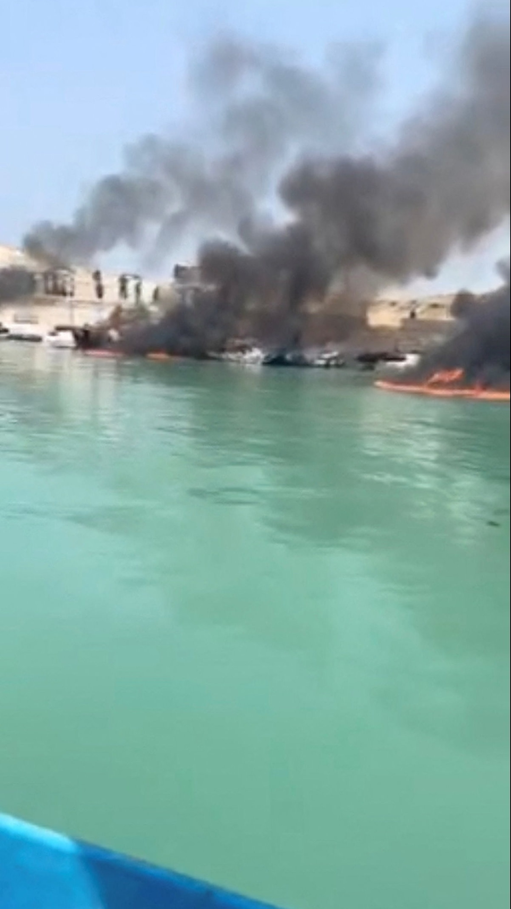 PHOTO: Smoke rises from boats on fire at a fishing pier in Banood, Bushehr Province, Iran, after a U.S. projectile struck the area according to the deputy governor of Bushehr Province, in this screengrab from social media, released July 9, 2026.