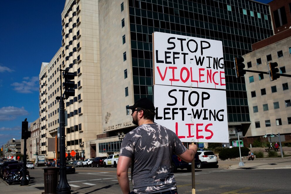 PHOTO: A rally attendee holds a sign facing cars as they pass by as people gather during a rally to remember conservative activist Charlie Kirk, who was fatally shot during an event at Utah Valley University, in Lansing, Mic., Sept. 15, 2025.