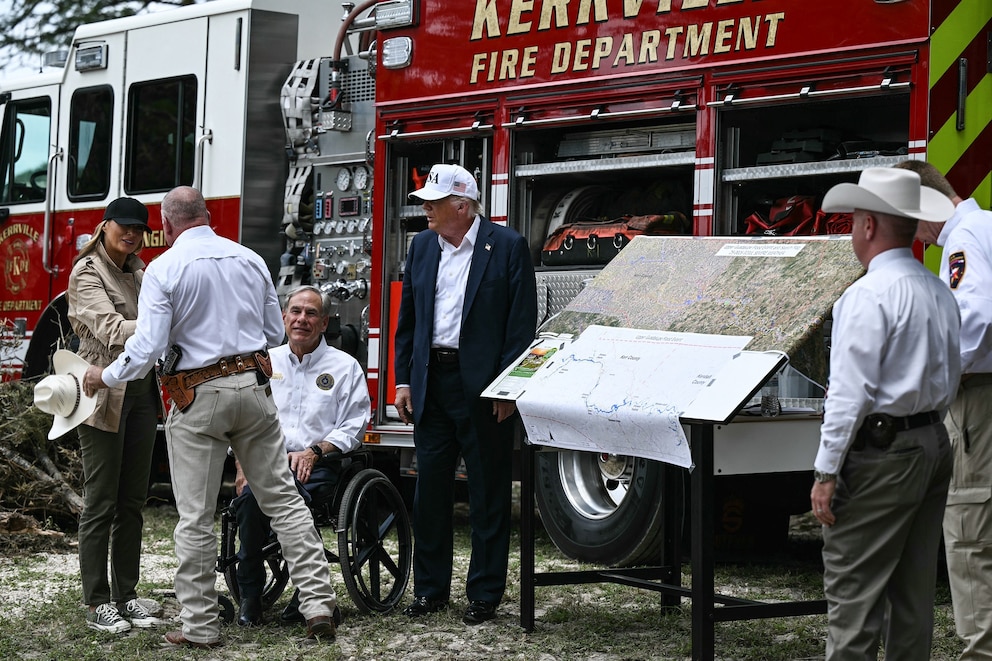 PHOTO: Donald Trump, Greg Abbott, and Melania Trump meet with local officials and first responders near the Guadalupe River following devastating flooding that ocurred in the area over the July 4 weekend, in Kerrville, Texas, on July 11, 2025.