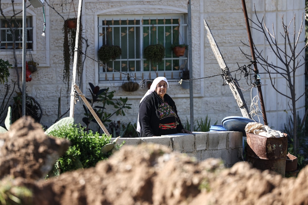 PHOTO: A Palestinian woman stands in the yard of her home as shops and homes belonging to Palestinian families in Beit Aawa, west the Israeli-occupied West Bank city of Hebron on Feb. 5, 2026.