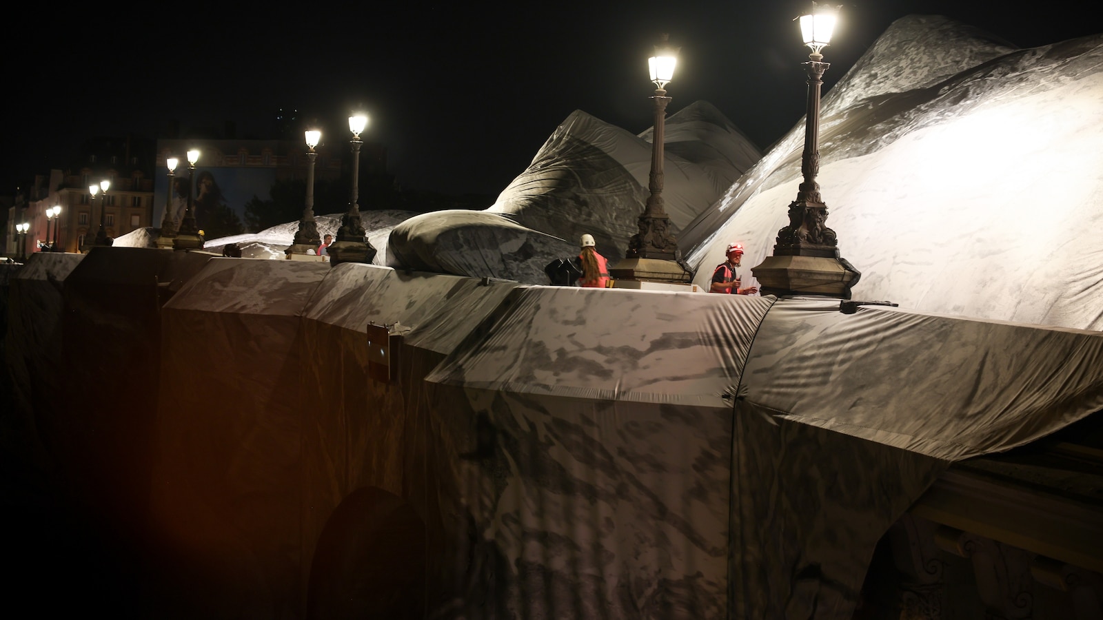 French artist JR begins his giant ‘cave’ art inflation over Paris’ oldest bridge