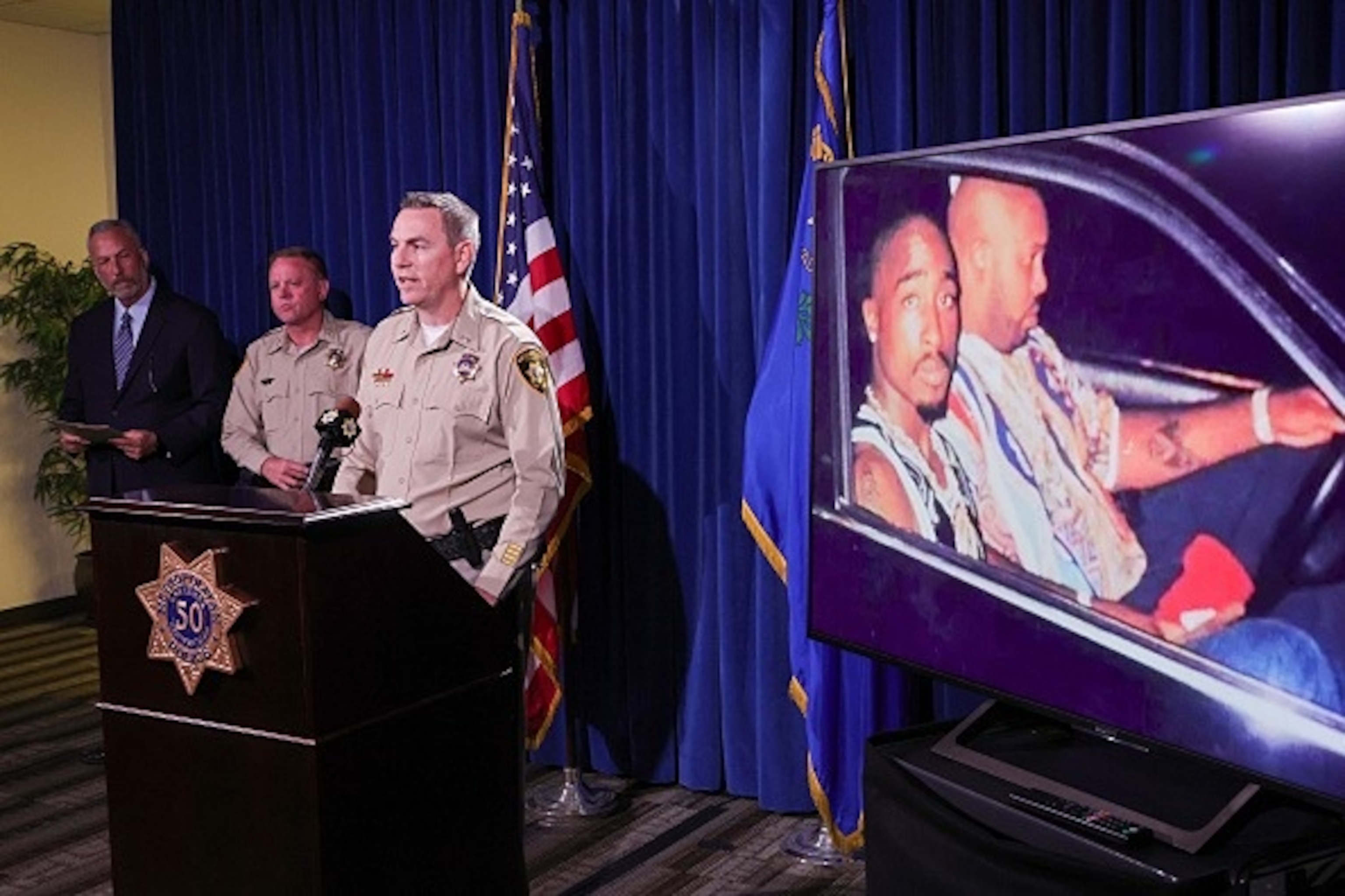 PHOTO: An image displayed on a monitor shows Tupac Shakur (L) and Marion "Suge" Knight Jr. in a car in Las Vegas the night Shakur was killed, as authorities announced murder charges against Duane “Keffe D” Davis, September 29, 2023. 
