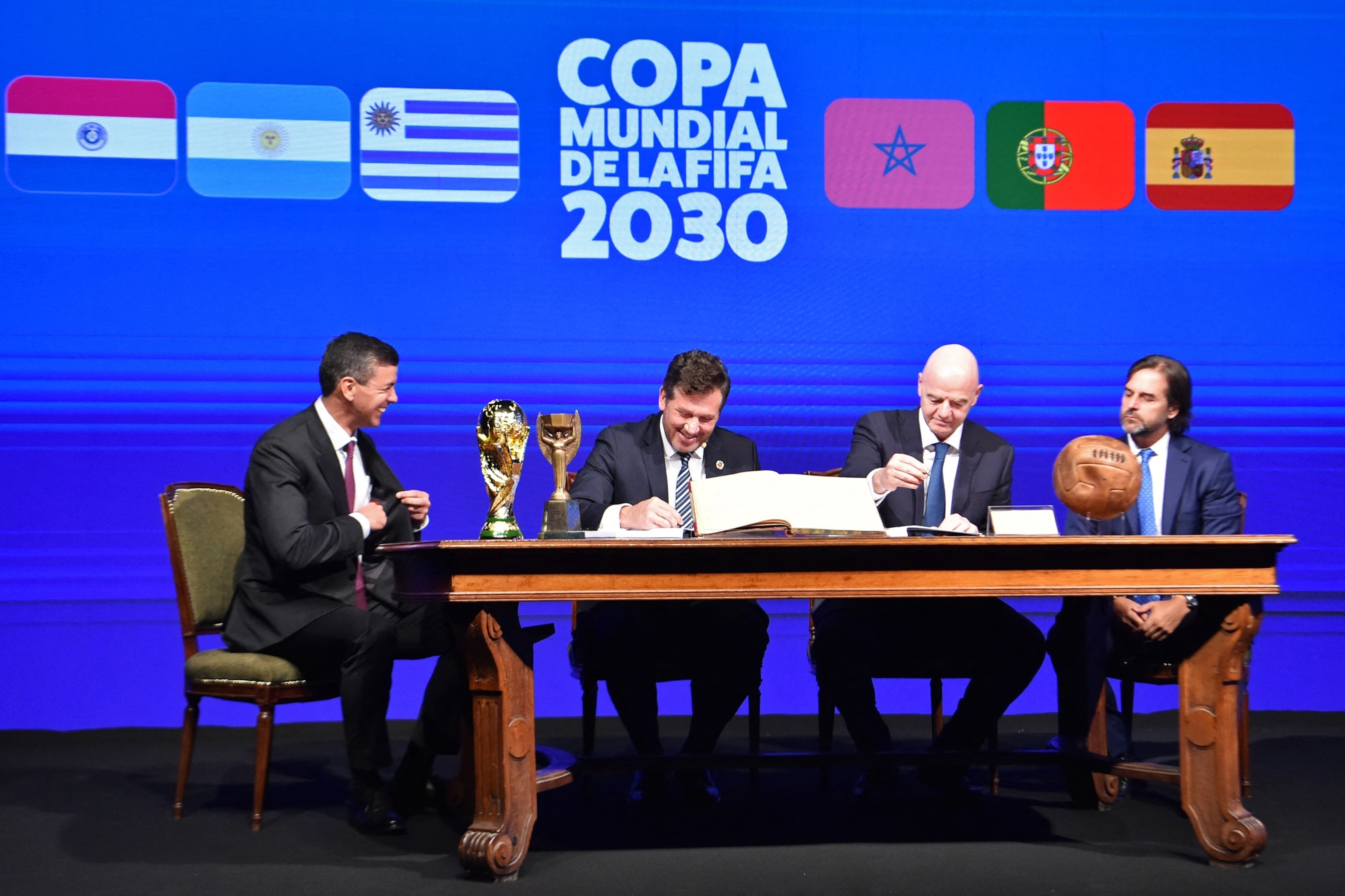 PHOTO: Conmebol's President Alejandro Dominguez and FIFA President Gianni Infantino accompanied by Paraguay's President Santiago Pena and Uruguay's President Luis Lacalle sign a book of minutes of the 2030 World Cup in Luque, Paraguay, April 11, 2024.
