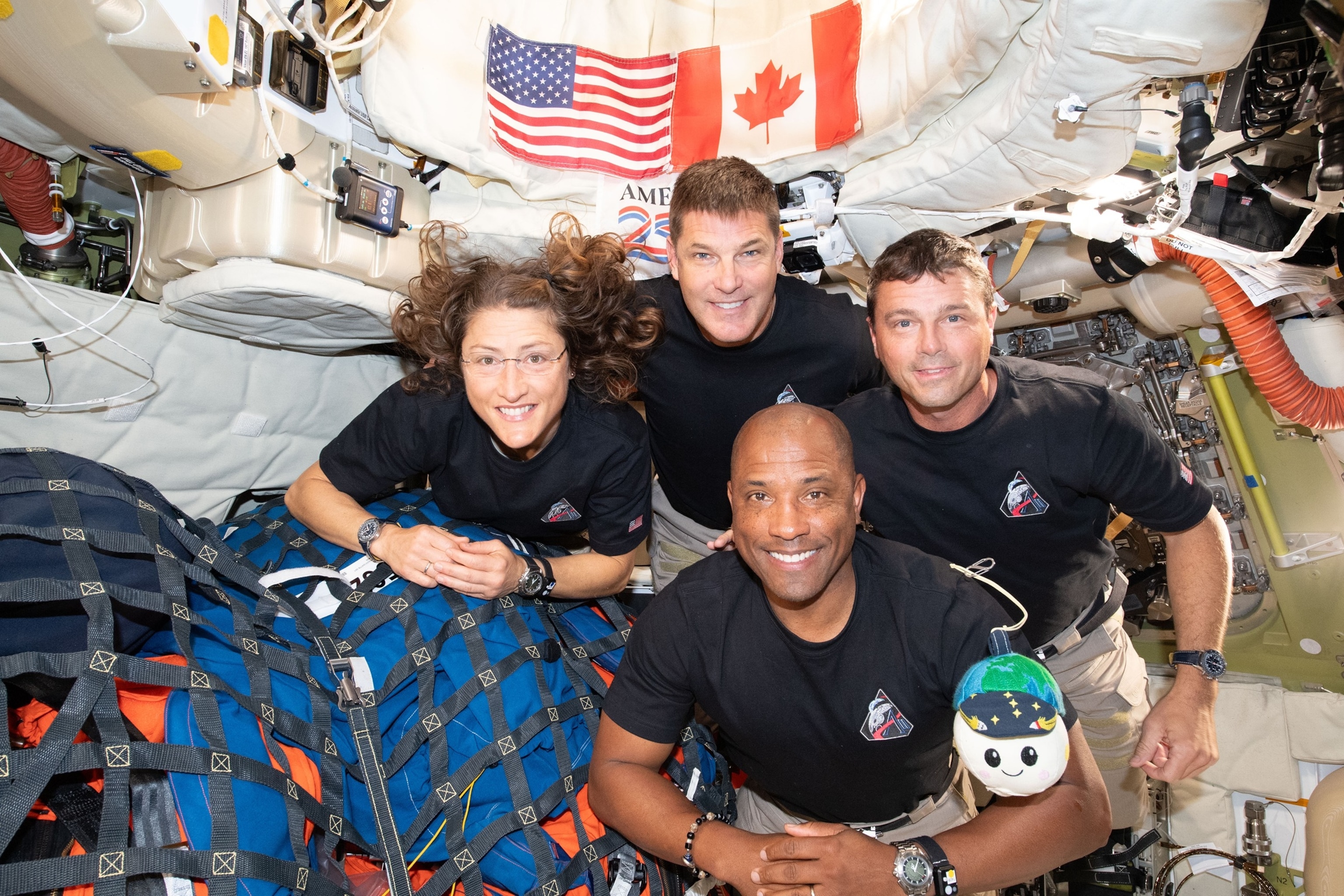 PHOTO: The Artemis II crew, Christina Koch, Jeremy Hansen, Victor Glover and Reid Wiseman pause for a group photo with their zero gravity indicator "Rise," inside the Orion spacecraft April 7, 2026 following a trip around the far side of the Moon.