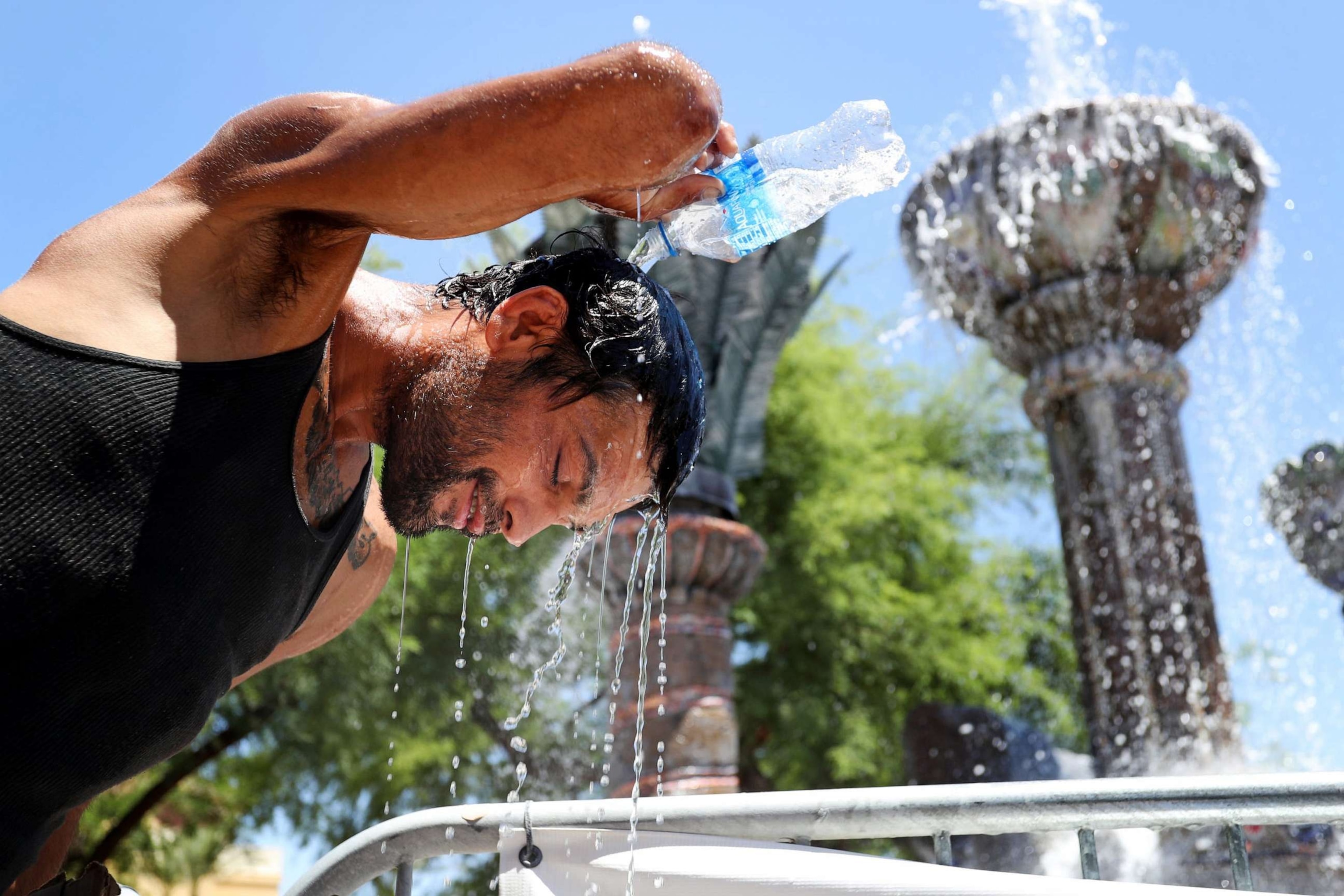 PHOTO: A man pours water over his head at the Fountain of Life in Cathedral City, Calif., on July 21, 2023. Temperatures in the Coachella Valley could reach 120 degrees.