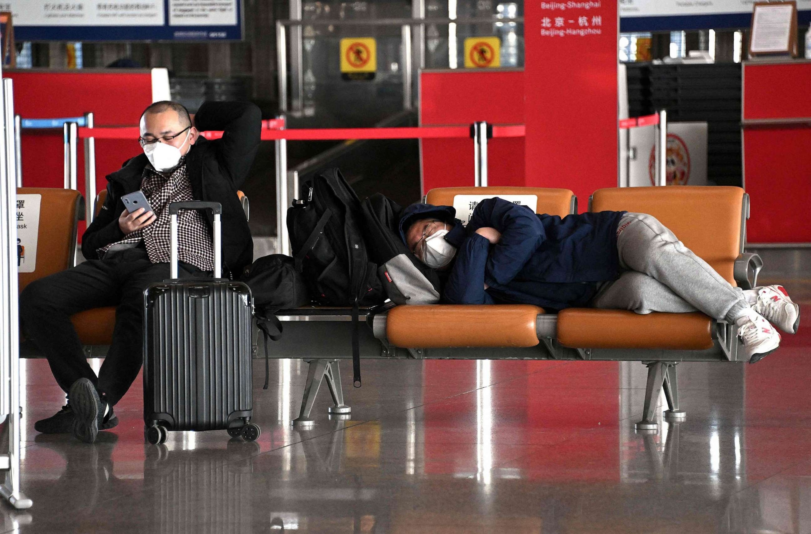 PHOTO: Passengers rest on a bench in a departure terminal of the international airport in Beijing, Dec. 29, 2022.