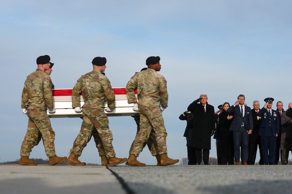 PHOTO: President Donald Trump salutes as members of the military carry transfer cases of the remains of Iowa National Guard members Sgt. Edgar Torres Tovar and Sgt. William Howard at Dover Air Force Base in Dover, Delaware, Dec. 17, 2025. 