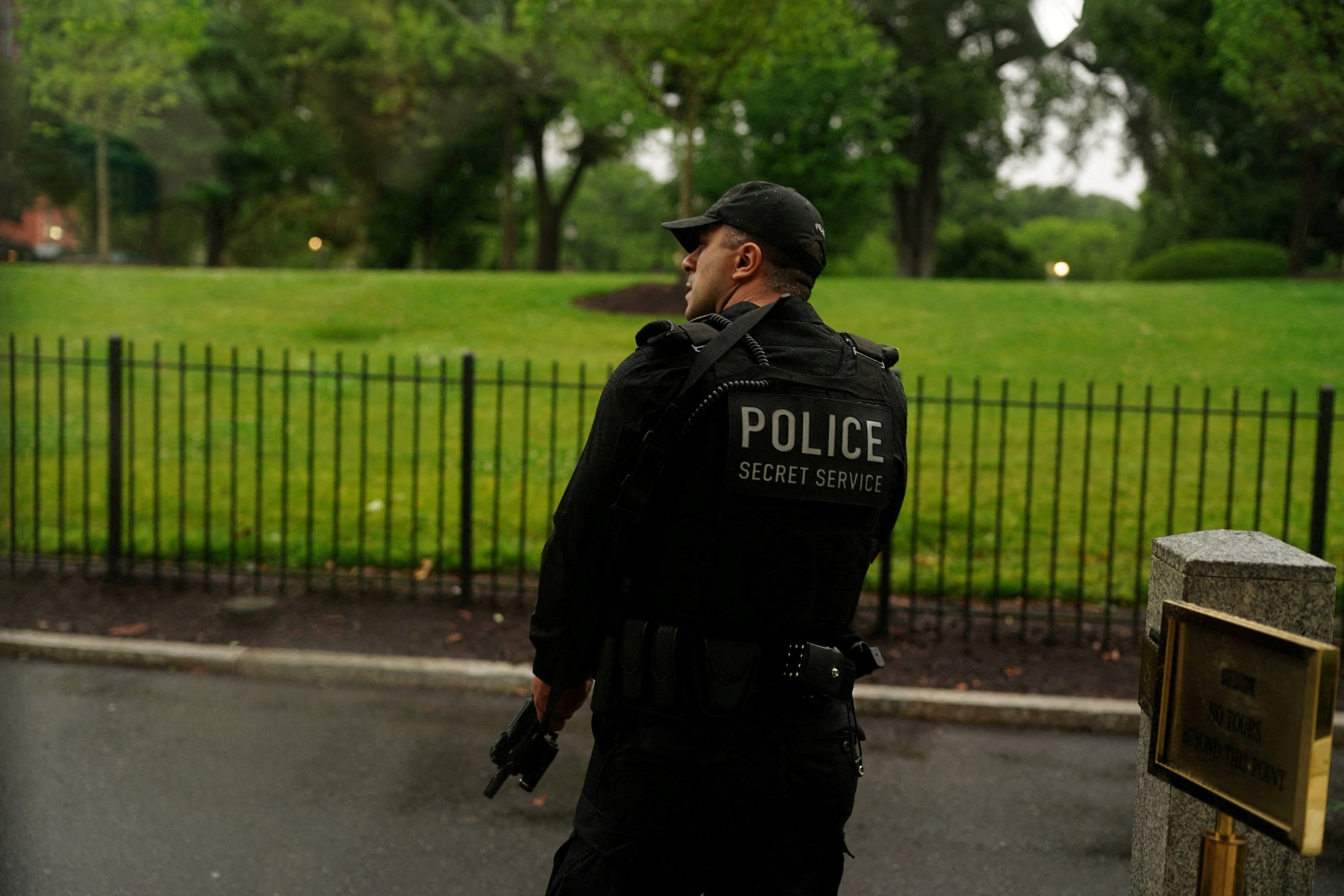PHOTO: A member of the U.S. Secret Service watches holding his weapon after alleged gunshots were heard nearby, at the White House in Washington