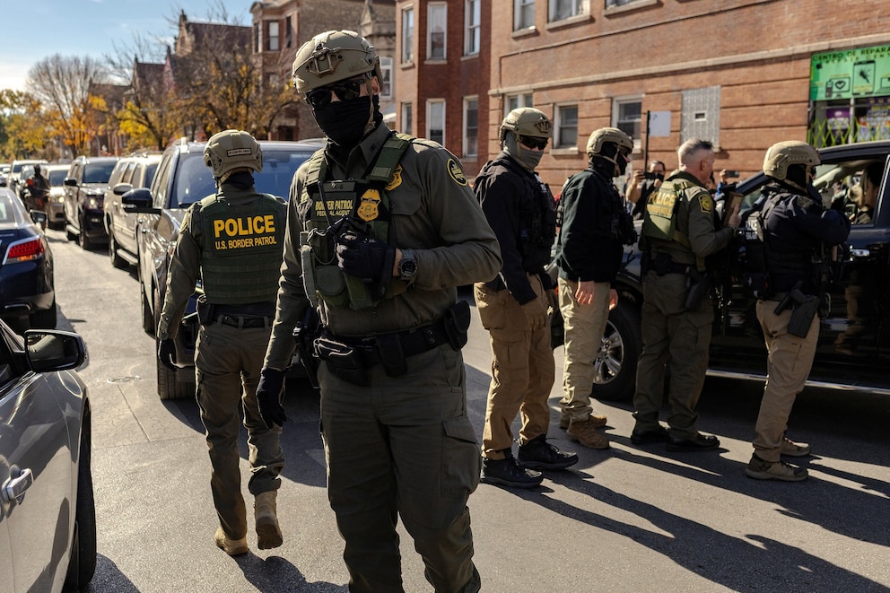 PHOTO: Federal agents stand off with community members during immigration raids