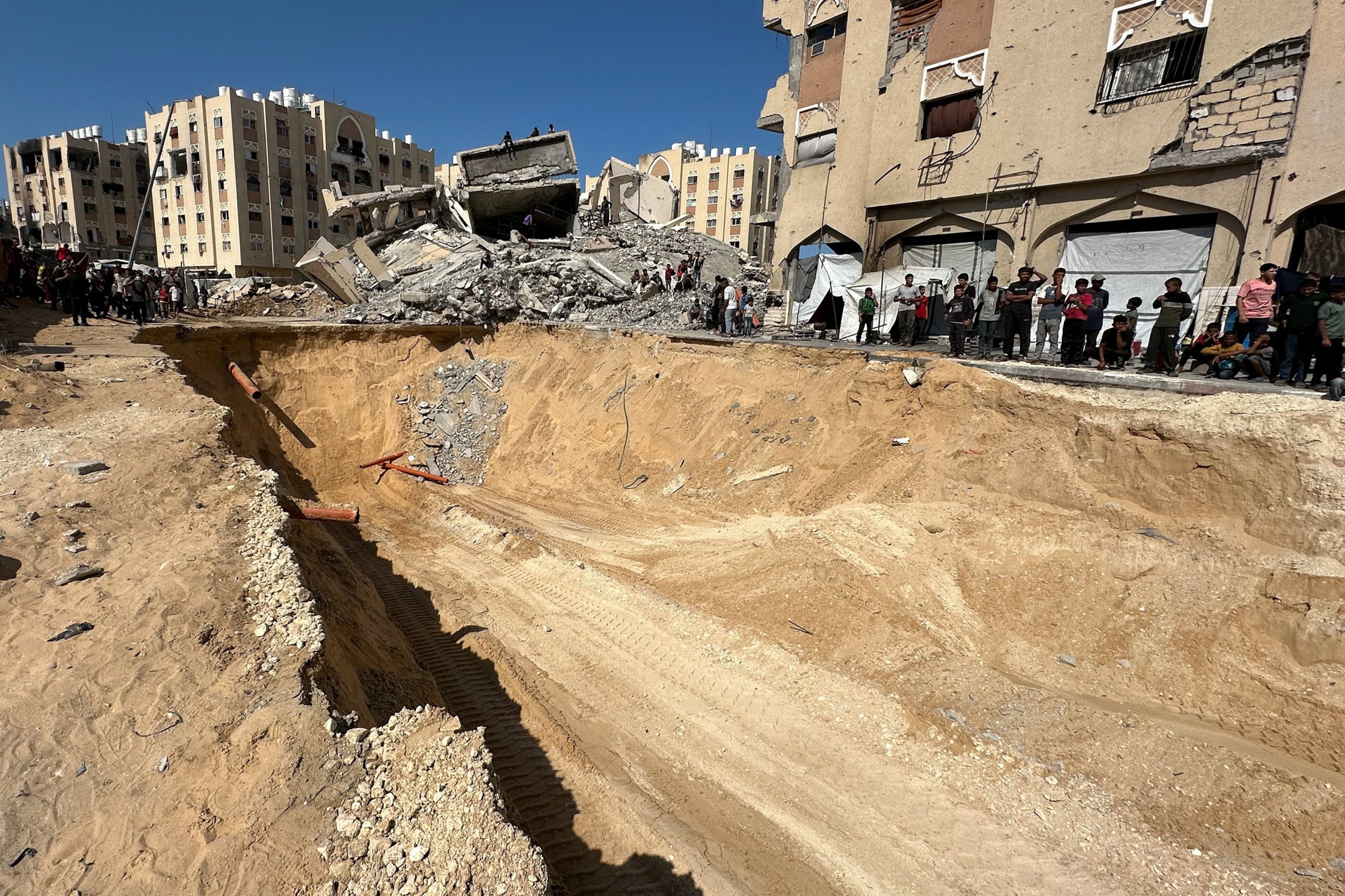PHOTO: Palestinians gather near a site where searches are underway for the bodies of hostages killed after being seized by Hamas during the October 7, 2023 attack, in Khan Younis, southern Gaza Strip, Oct. 17, 2025. 